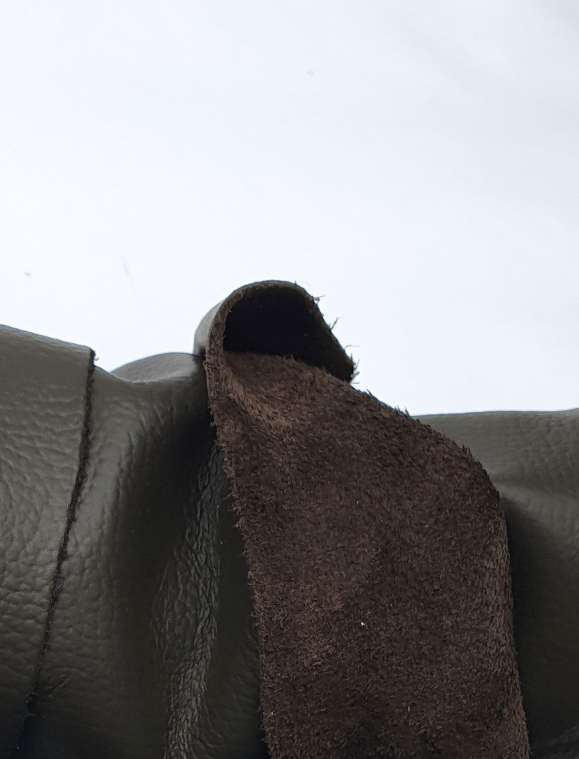 Close-up of dark brown leather with different textures between front and back 