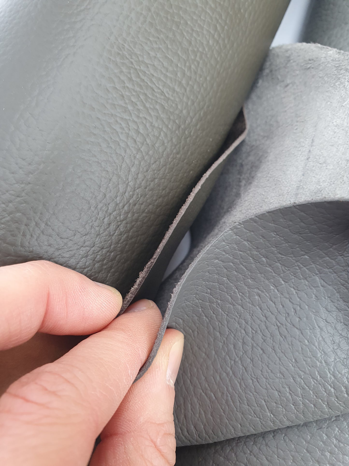 Close-up of grey leather with different textures between front and back 