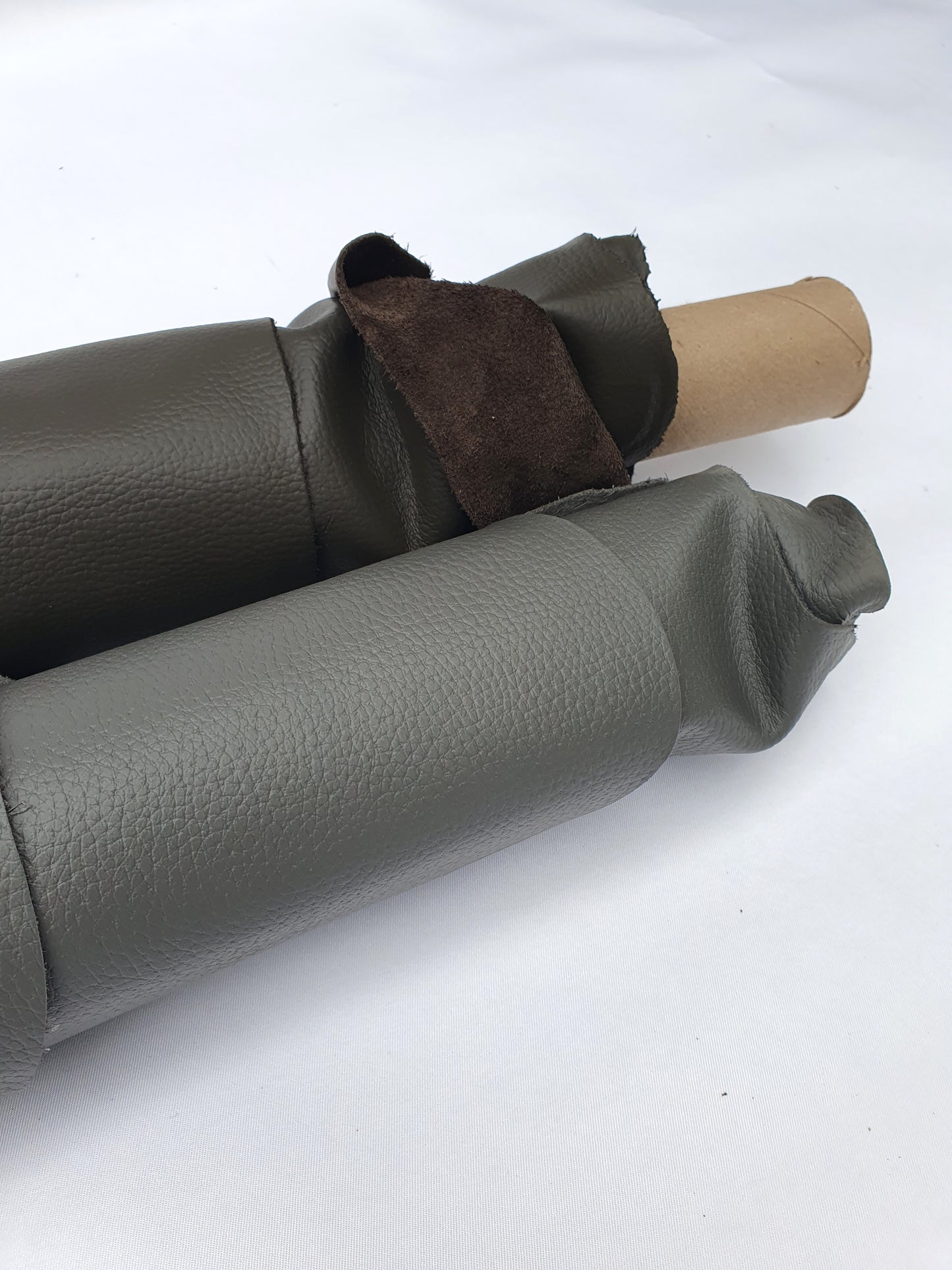 Close-up of rolled dark grey to brown leather showing a soft texture and folded edge