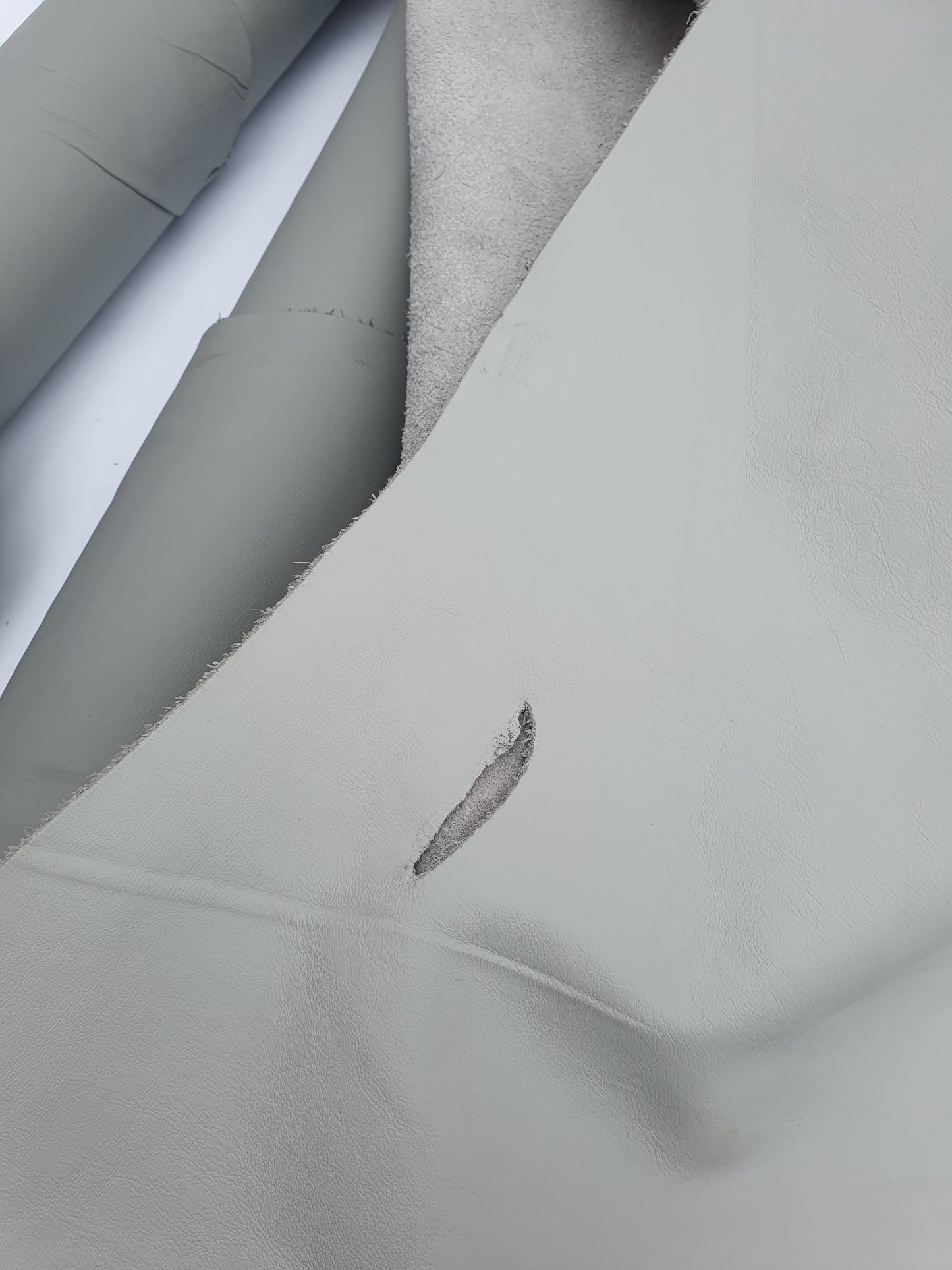 Two rolled leather in grey and light grey, some parts are holed