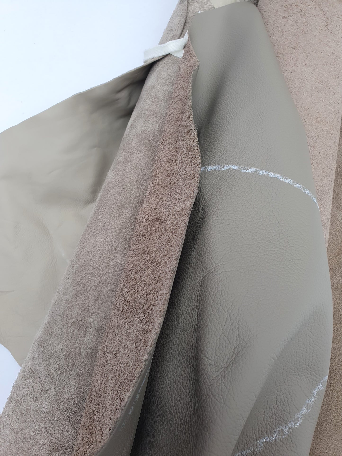 Collection of mushroom coloured rolled leather with visible marking lines 