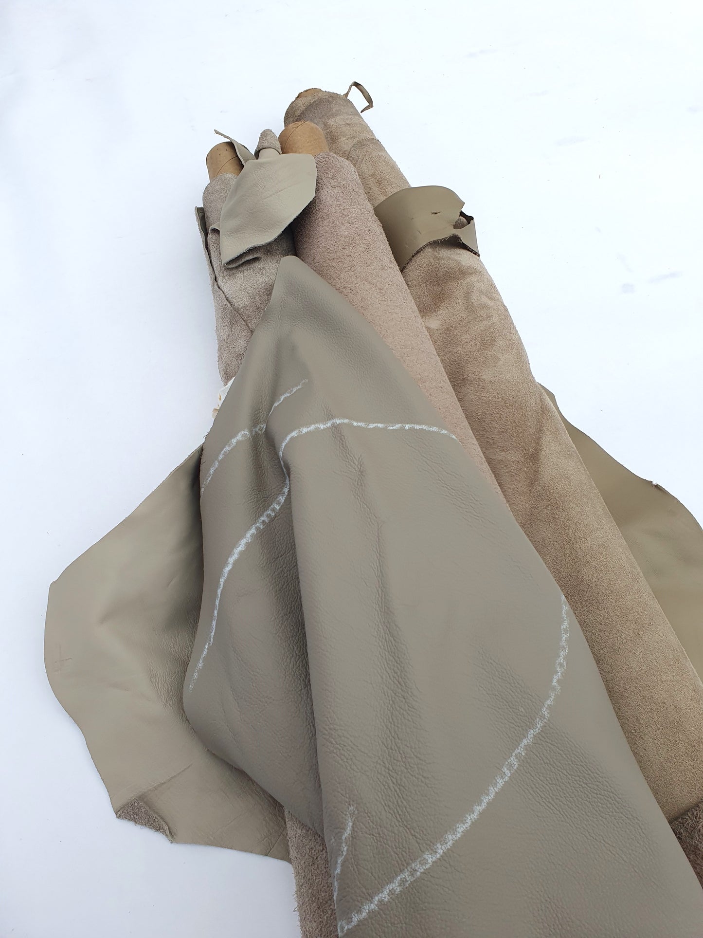 Collection of mushroom coloured rolled leather with visible marking lines 