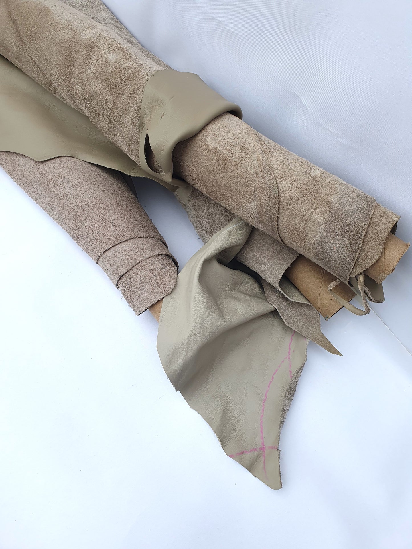 Collection of mushroom coloured rolled leather with visible marking lines 