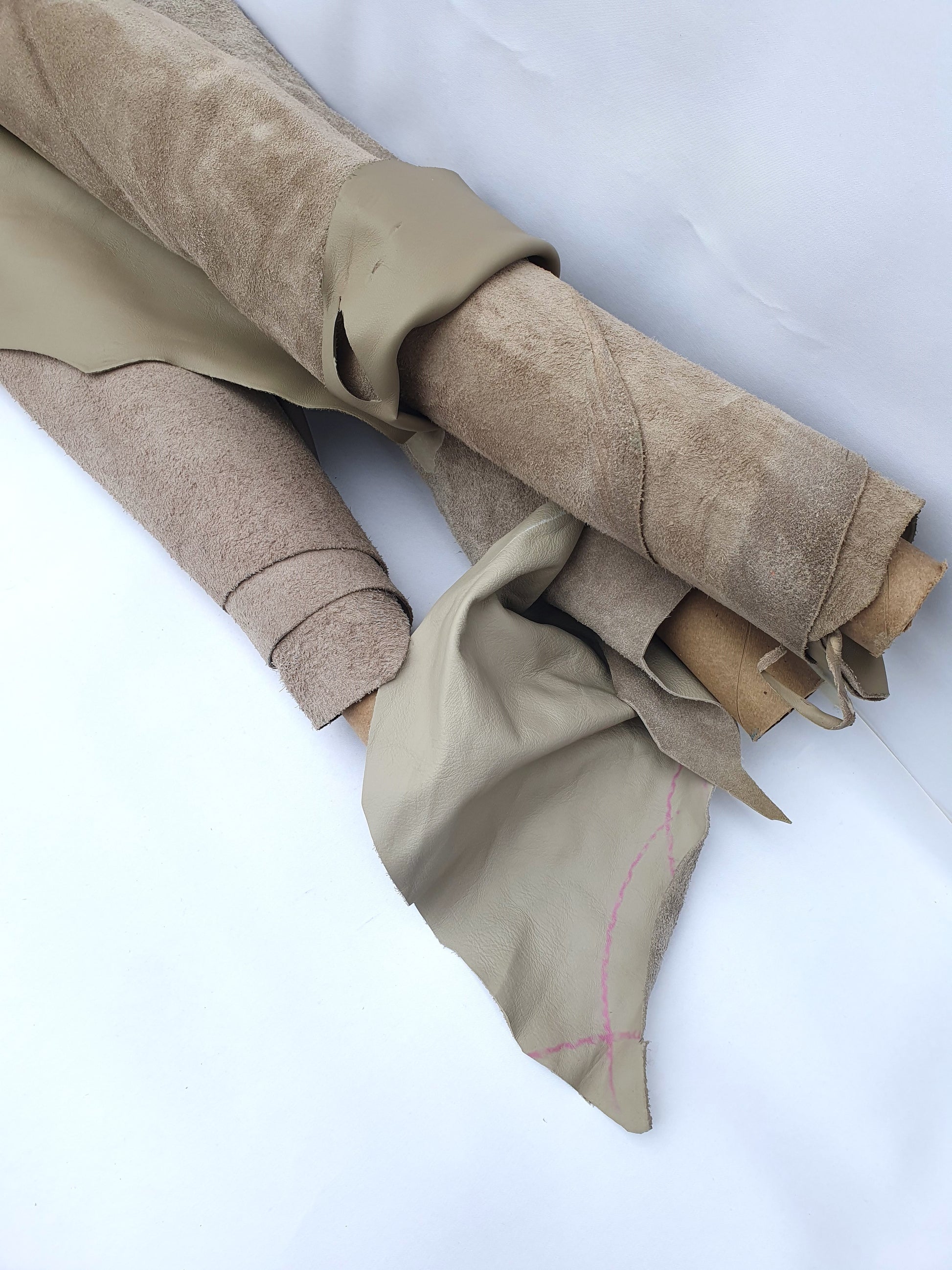 Collection of mushroom coloured rolled leather with visible marking lines 