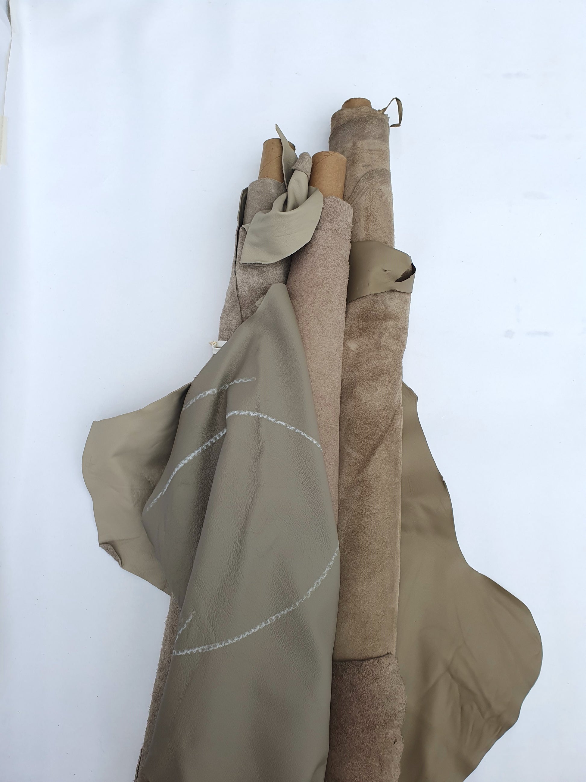 Collection of mushroom coloured rolled leather with visible marking lines 