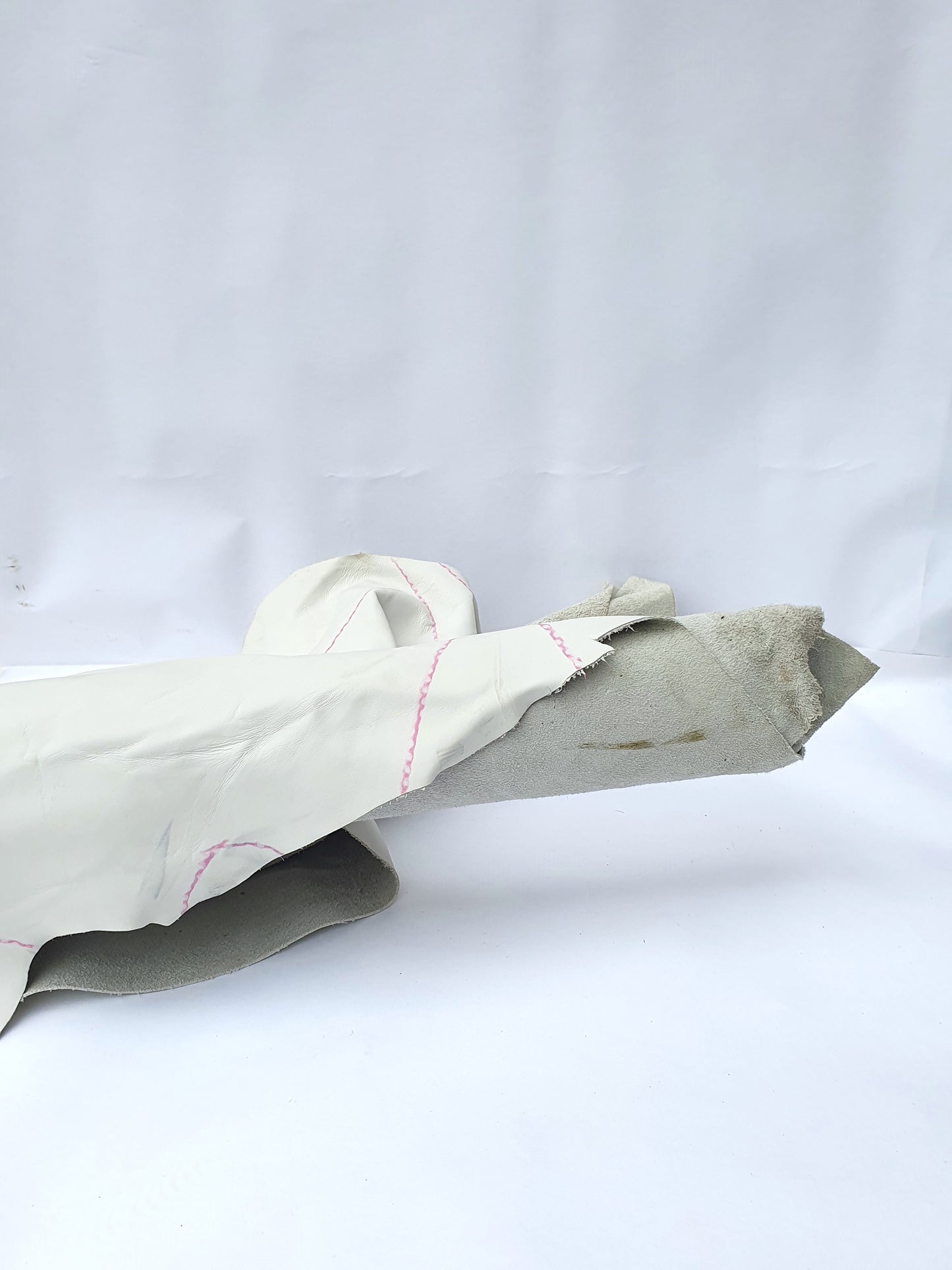 White rolled leather with visible markings and a rough texture