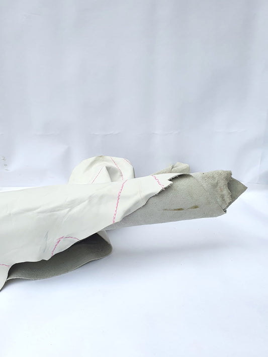 White rolled leather with visible markings and a rough texture