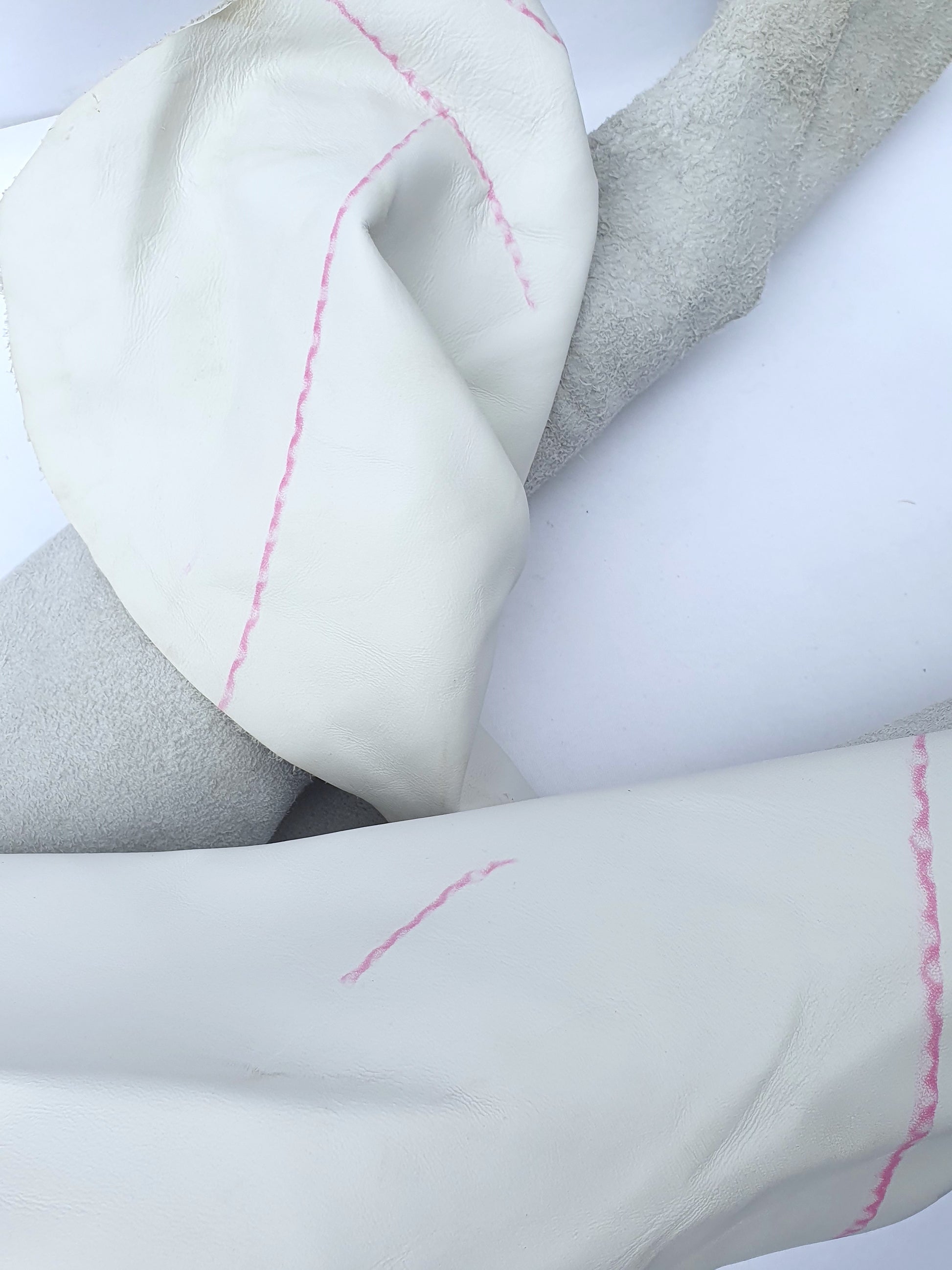 White rolled leather with visible markings and a rough texture