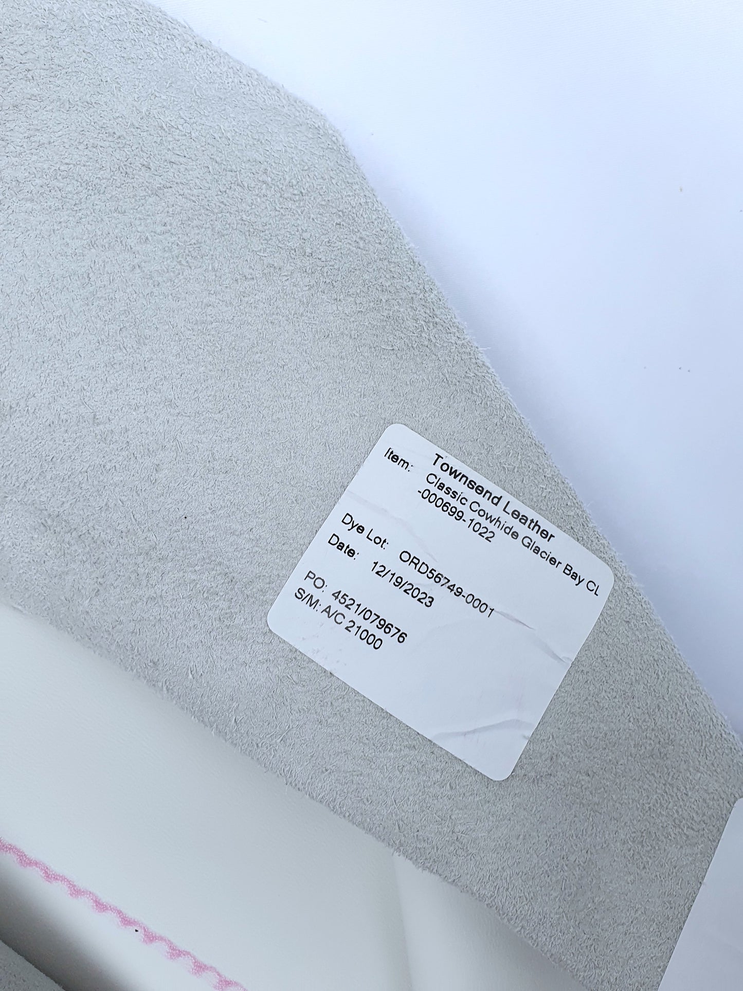 White rolled leather with a label contents its details 