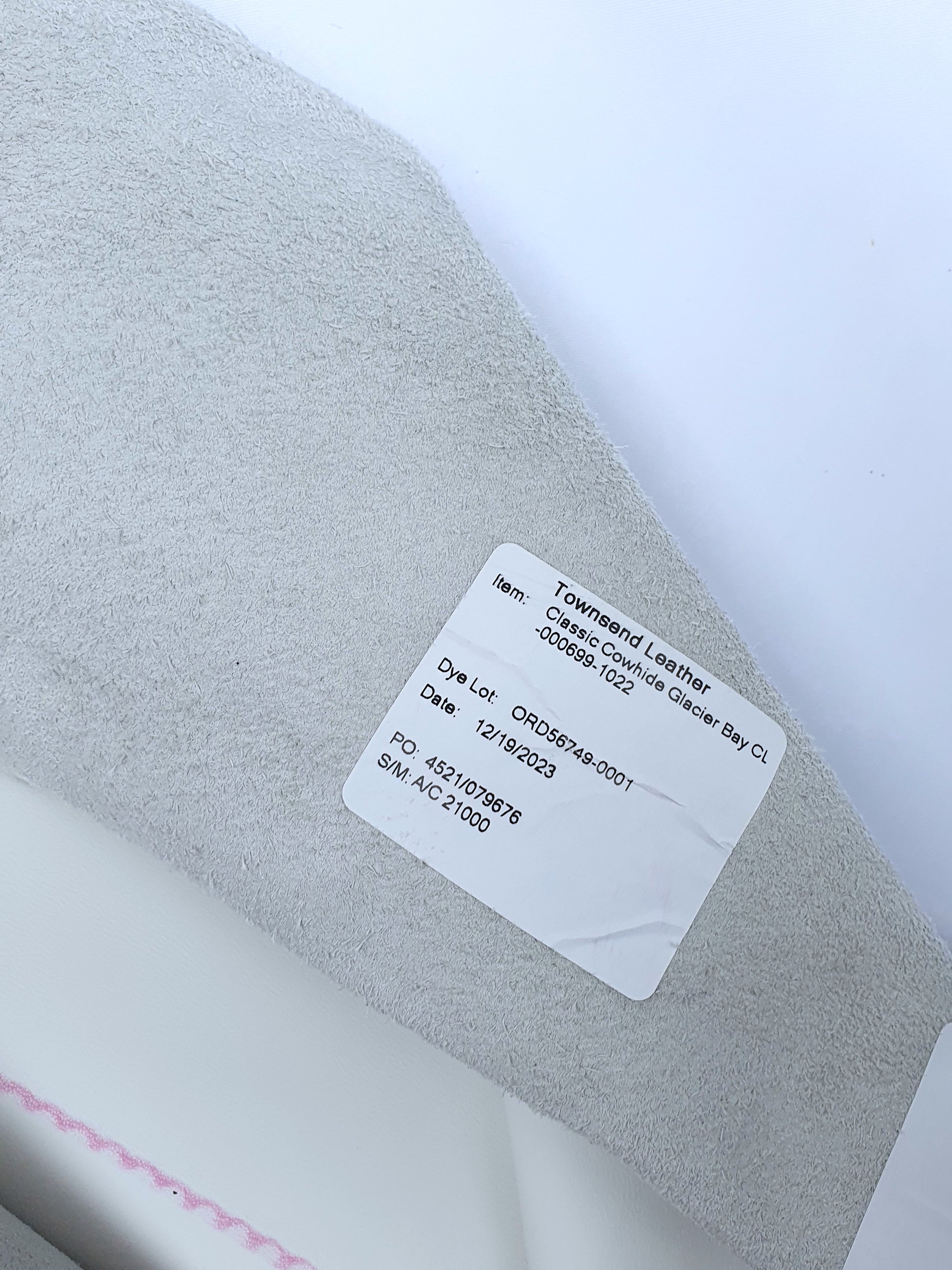 White rolled leather with a label contents its details 