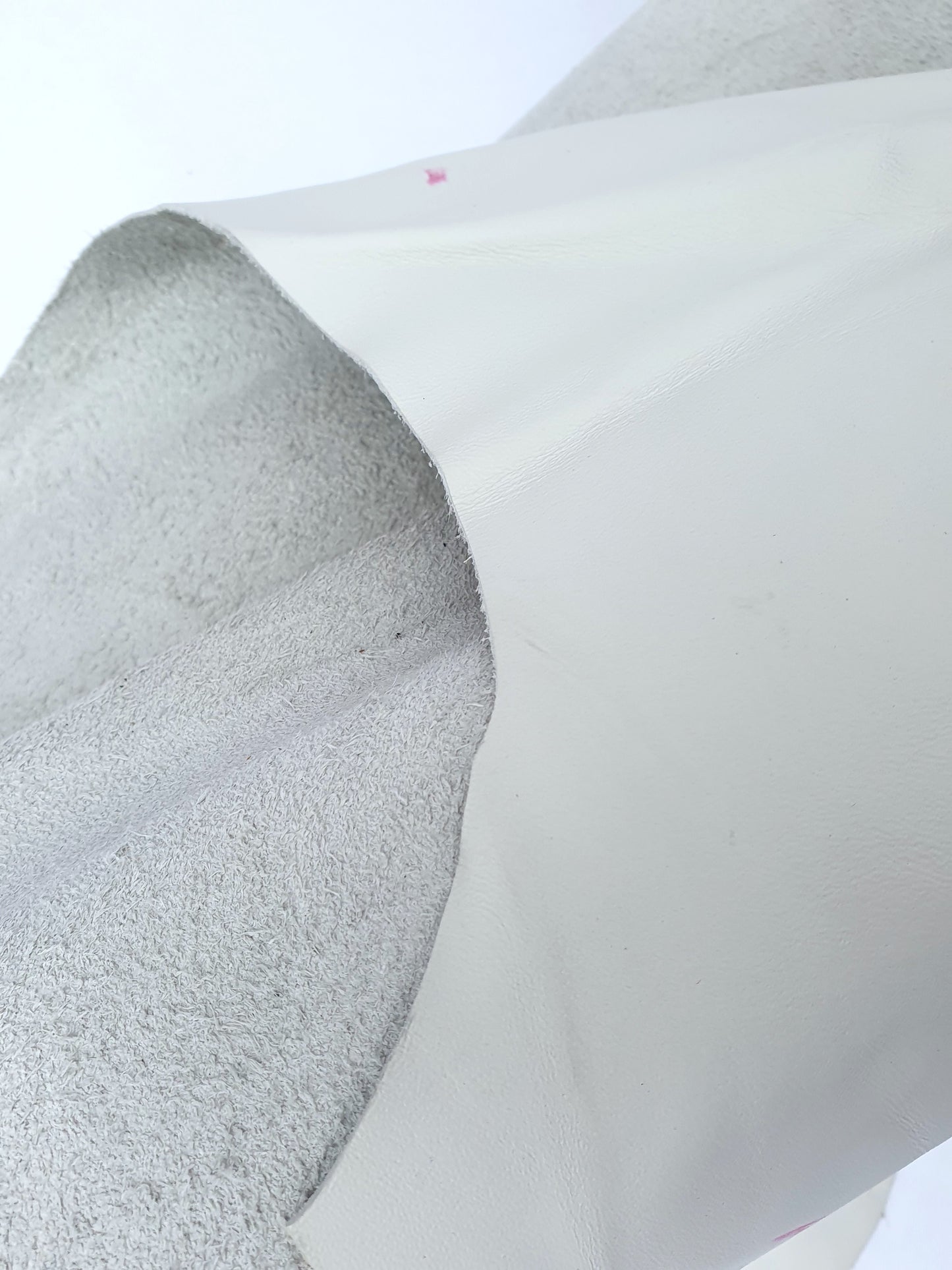 White rolled leather with visible markings and a rough texture