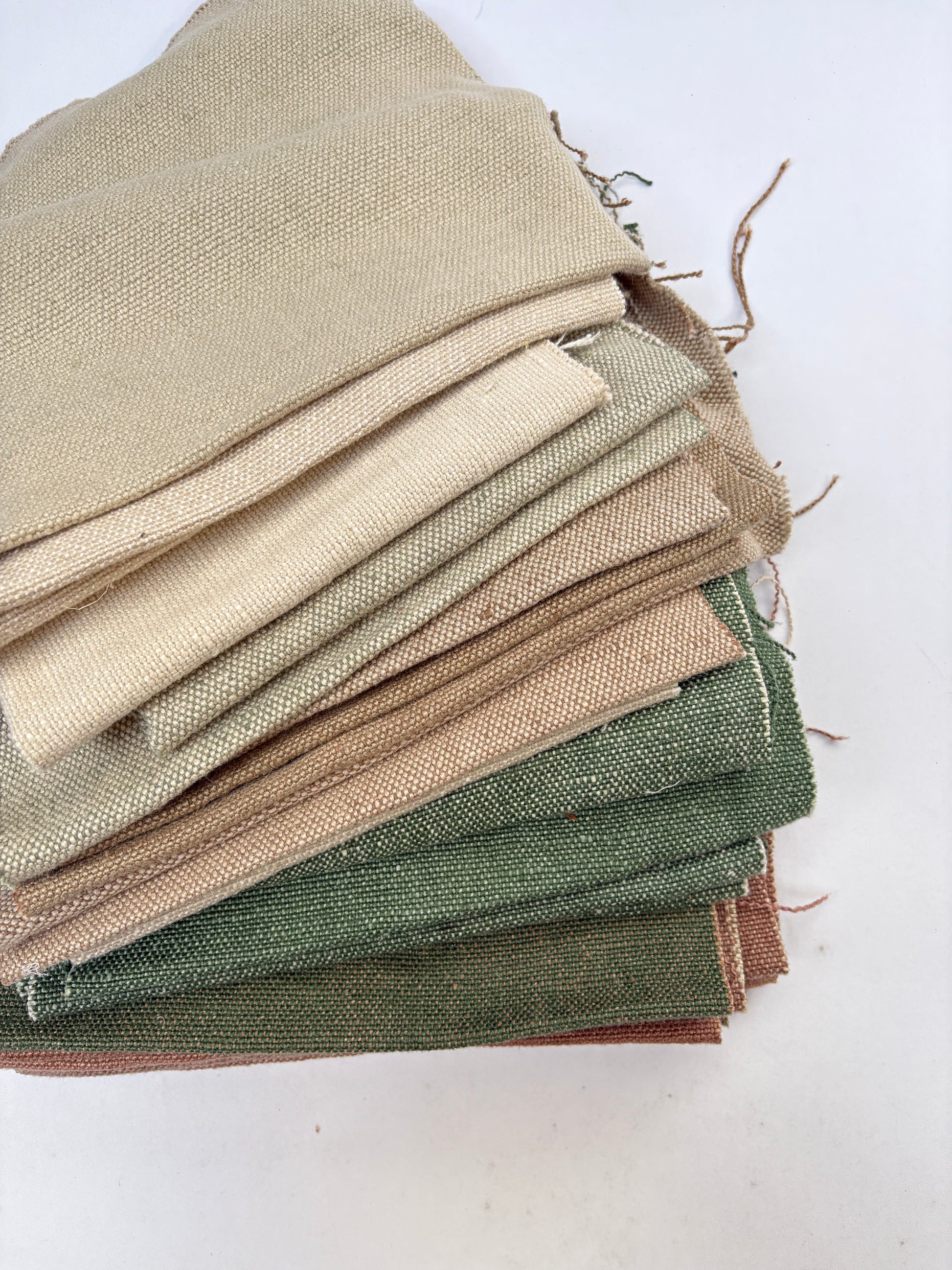 Stack of linen fabric swatches in various colours and sizes
