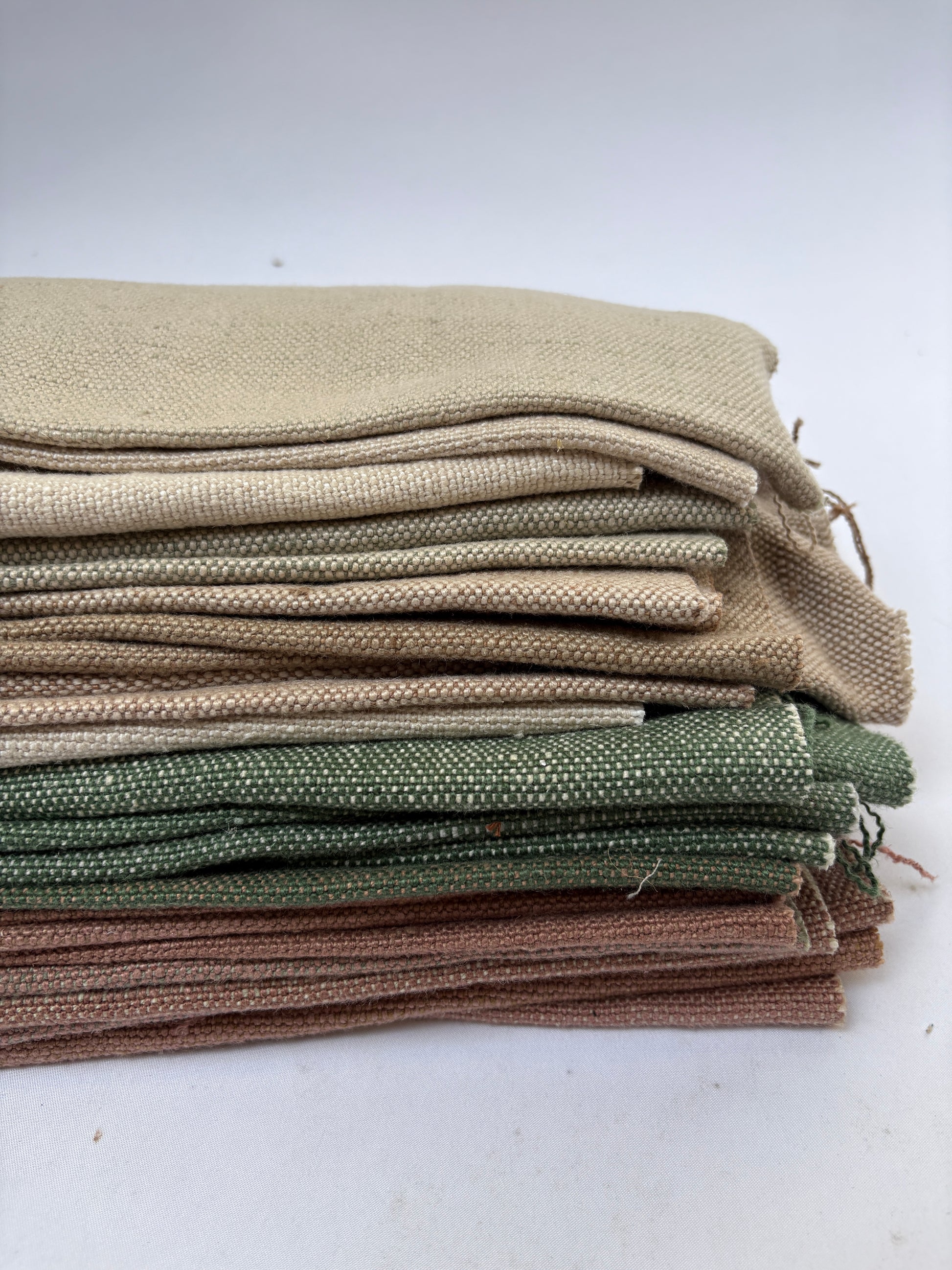 Close-up of a stack of linen fabric swatches in various colours 