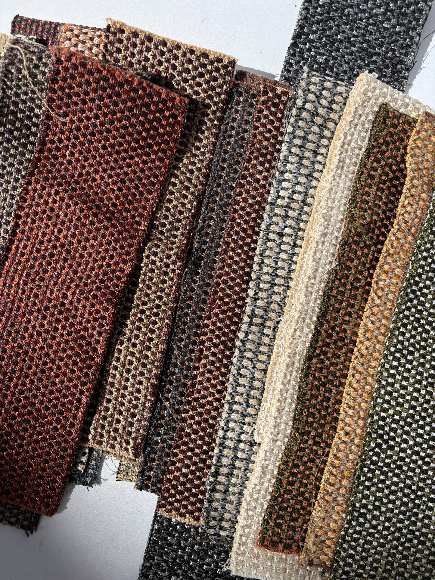 Long shimmer patterned fabric offcuts from a mixed bundle on white.