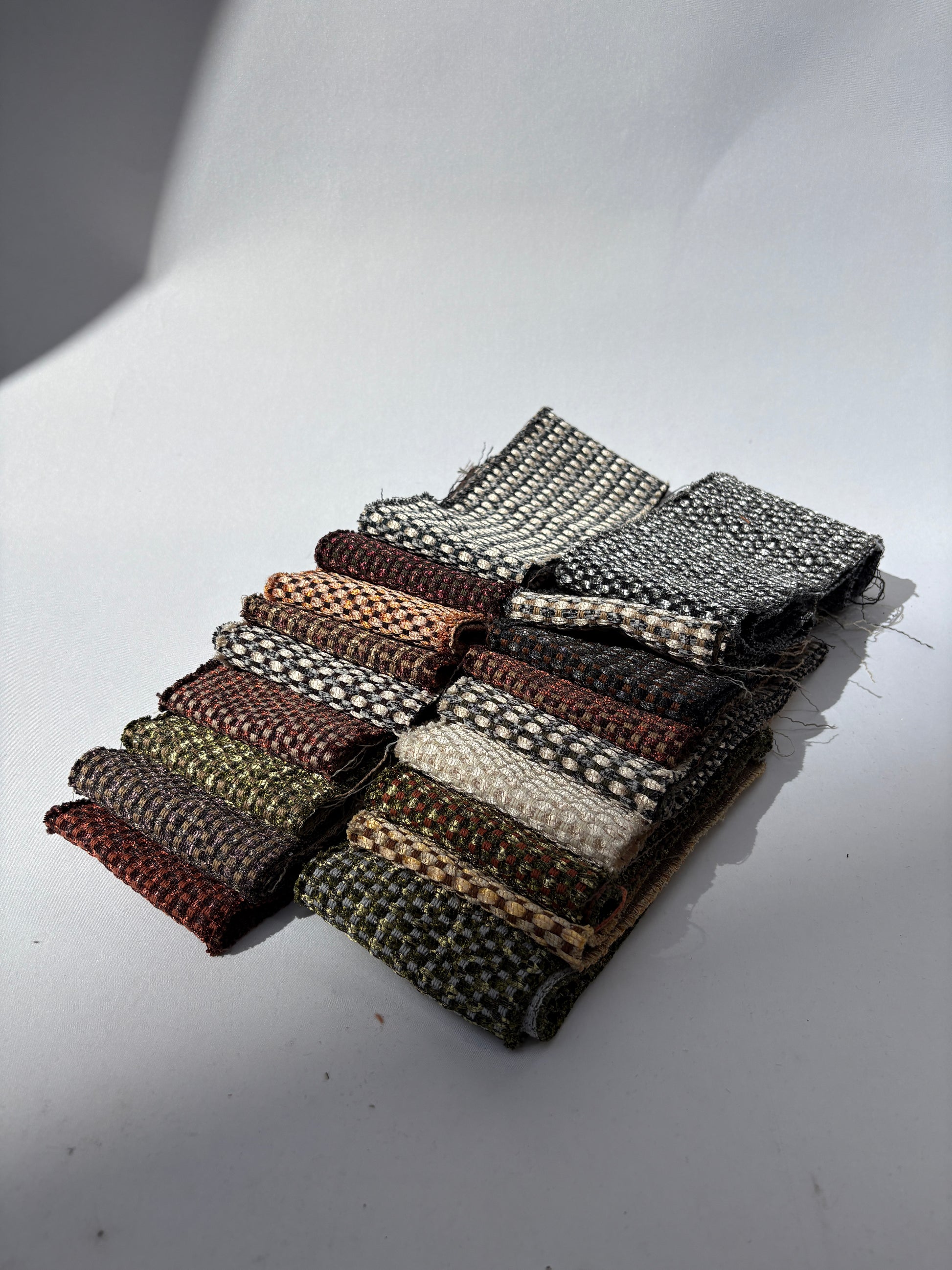 Assorted long fabric offcuts in mixed shimmer patterns displayed on white.