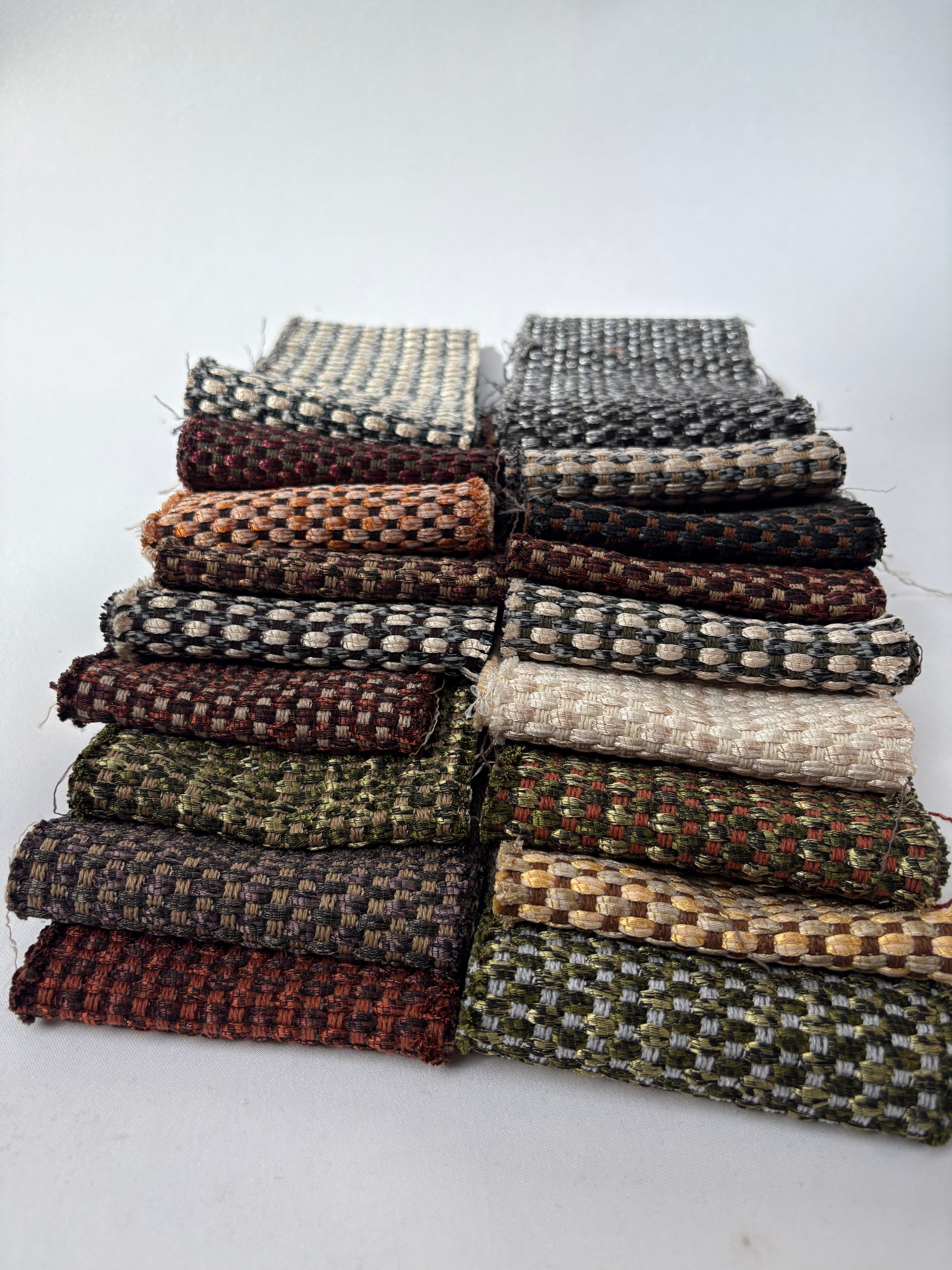 Mixed long fabric offcuts featuring shimmer patterns and woven textures on white.