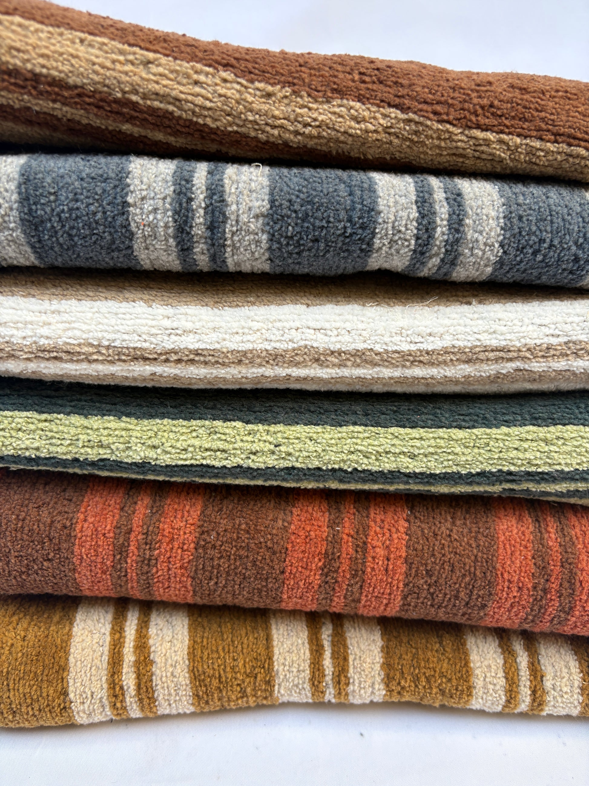 Close-up of a stack of striped patterned fabric in various colours