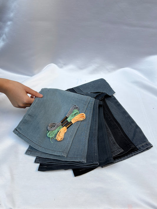 Denim fabric pieces in mixed washes with embroidery threads on white fabric.
