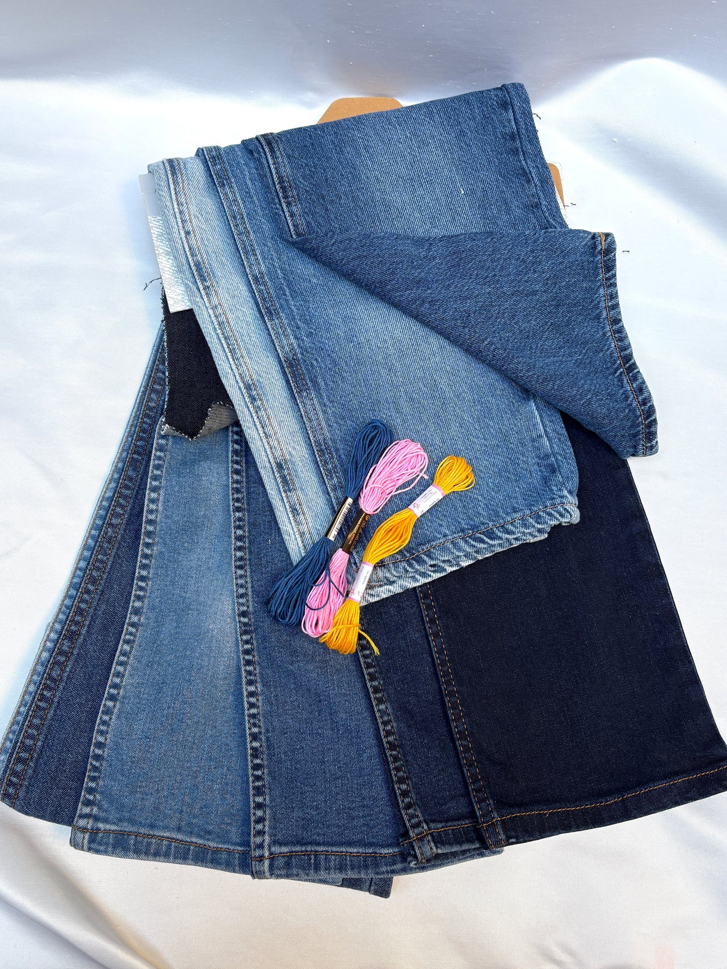 Mixed denim fabric pieces in layered blue washes with colourful embroidery threads.