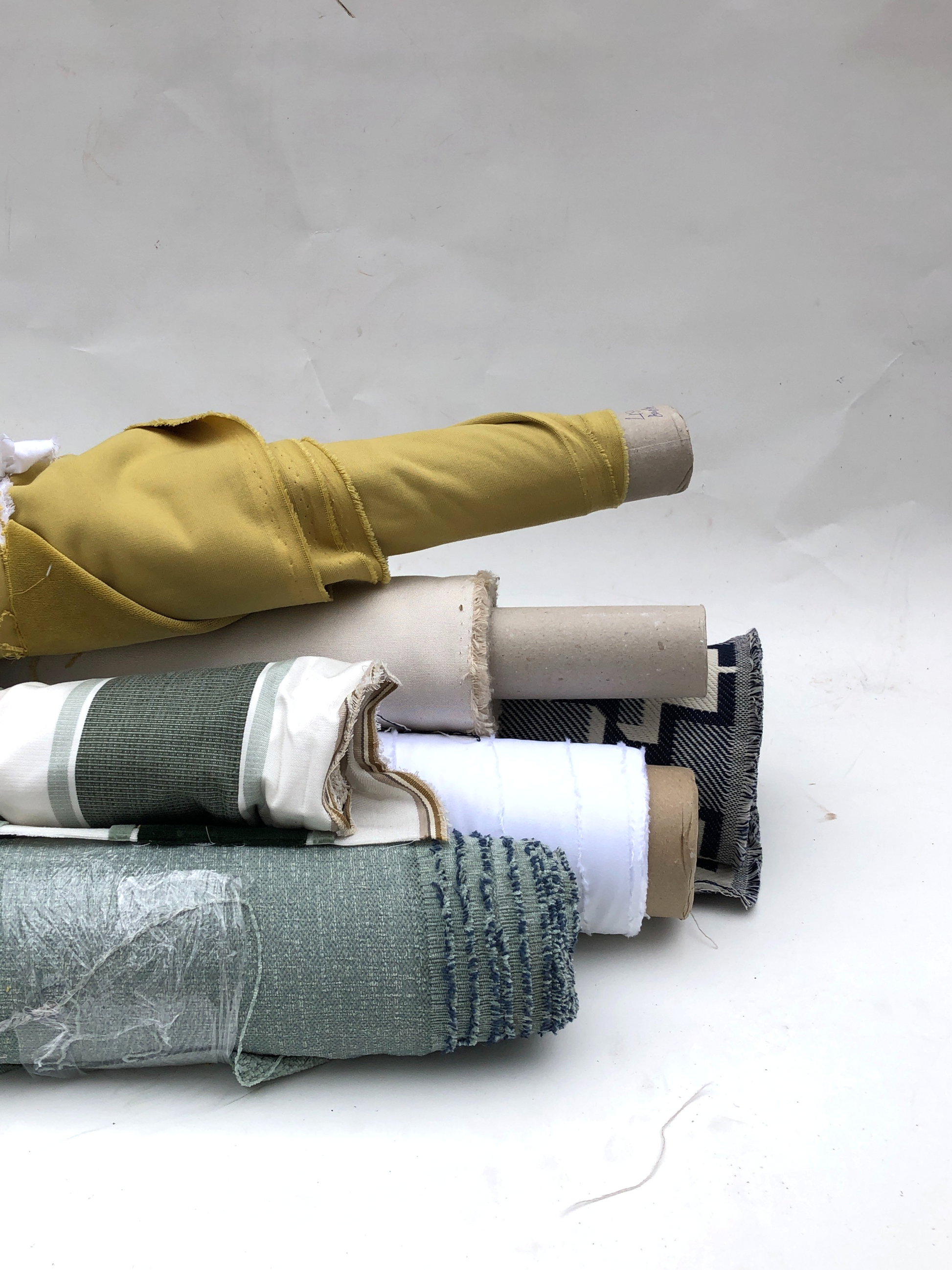 Collection of various coloured, patterned, rolled fabrics