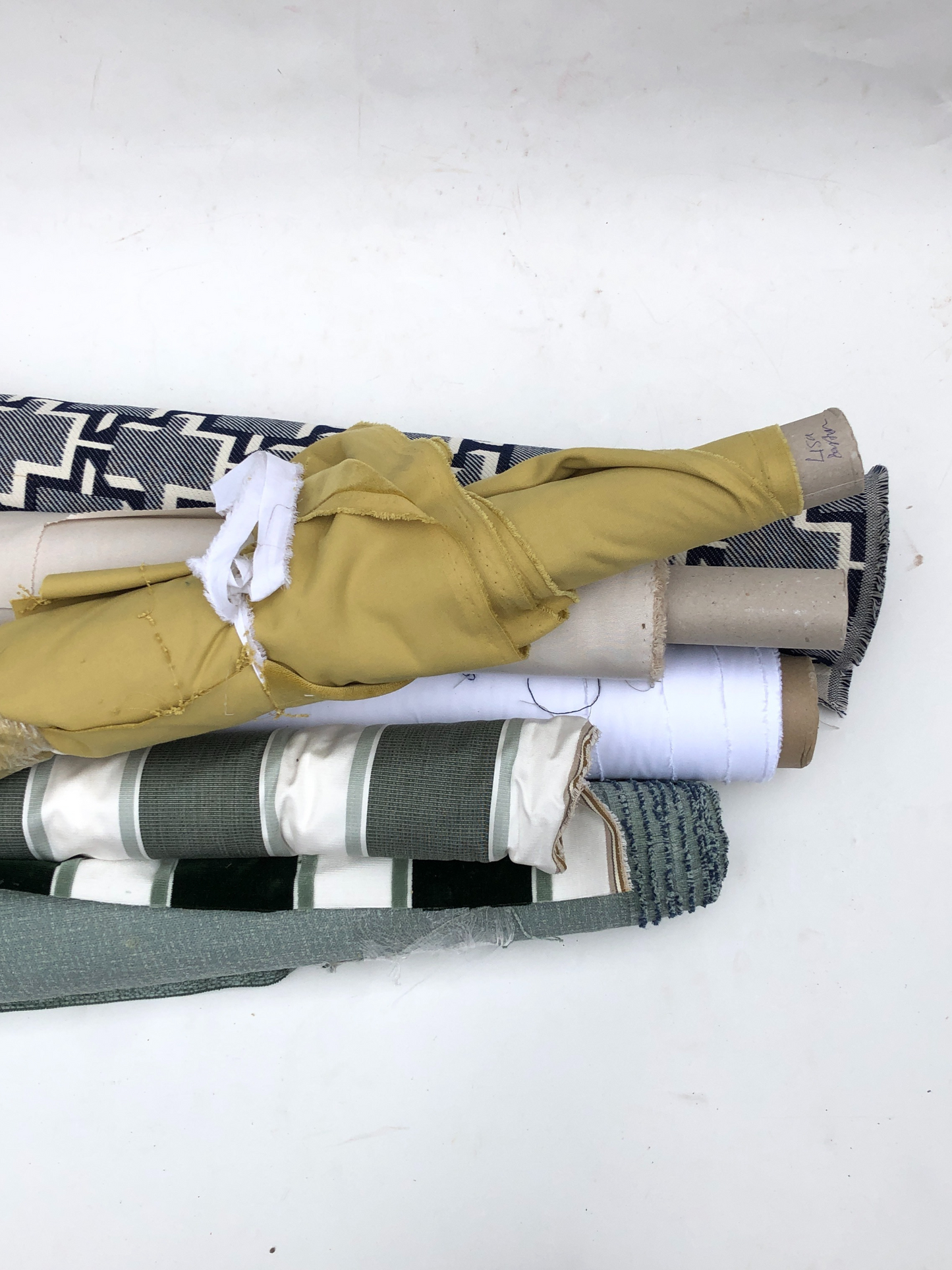 Collection of various coloured, patterned, rolled fabrics