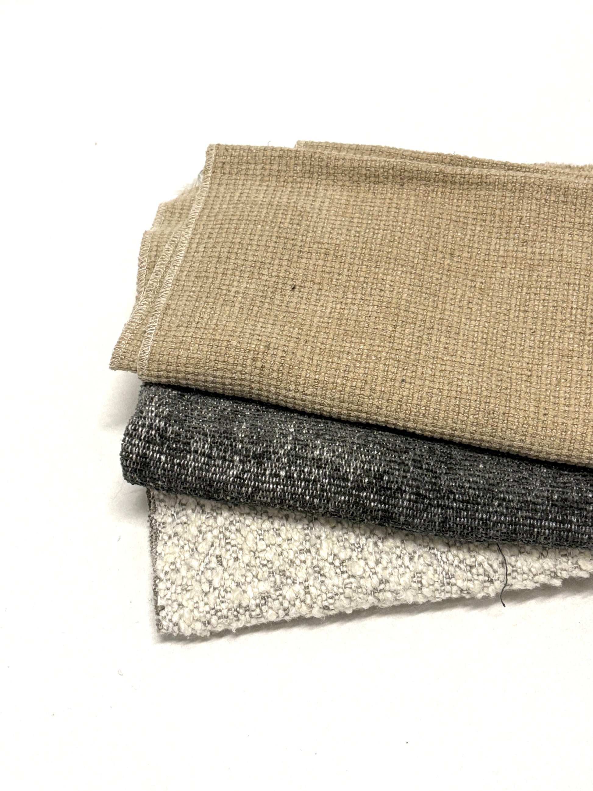 Stack of three neutral coloured heavyweight fabrics, texture visible