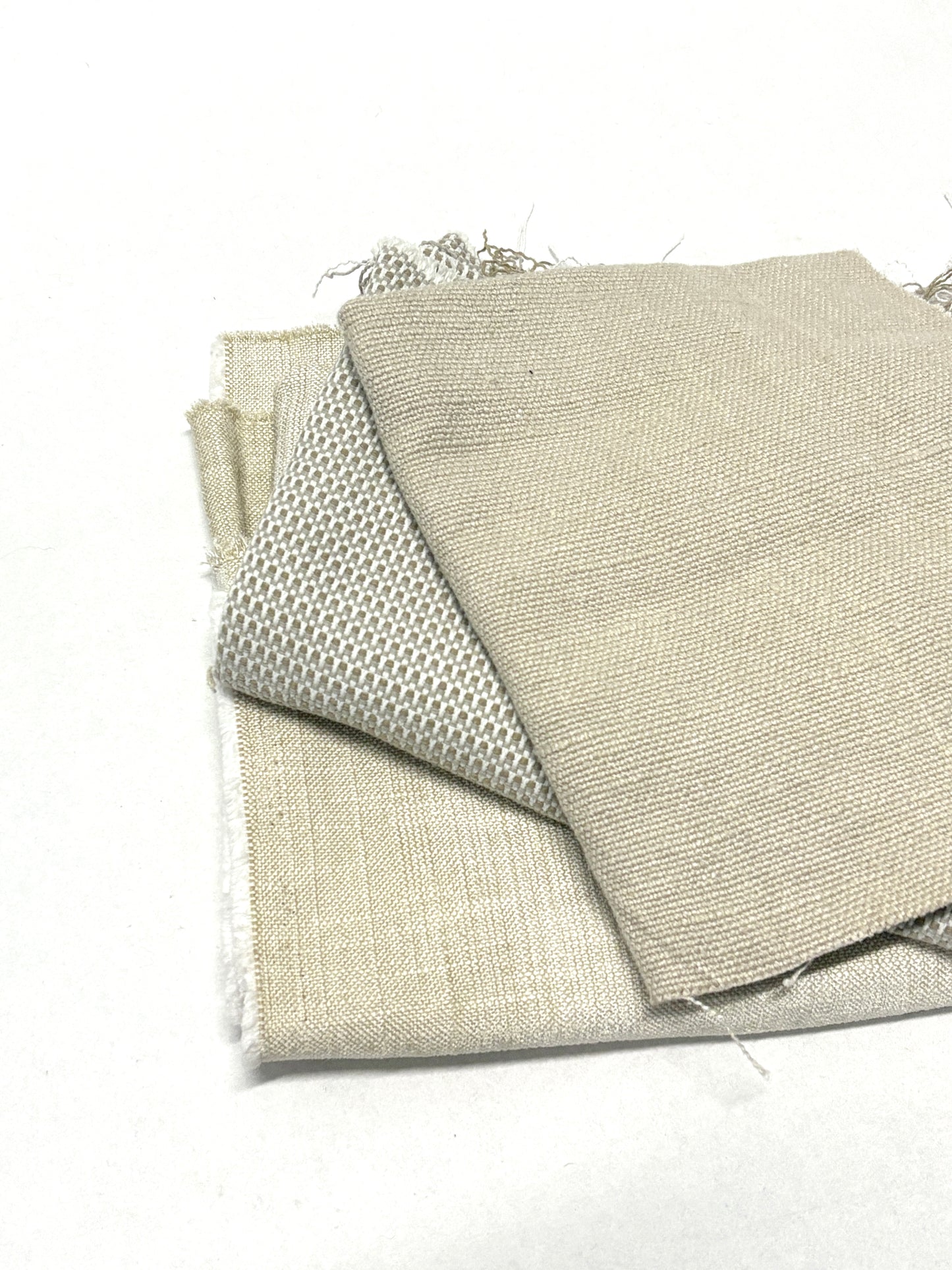 Stack of three neutral coloured heavyweight fabrics, texture visible