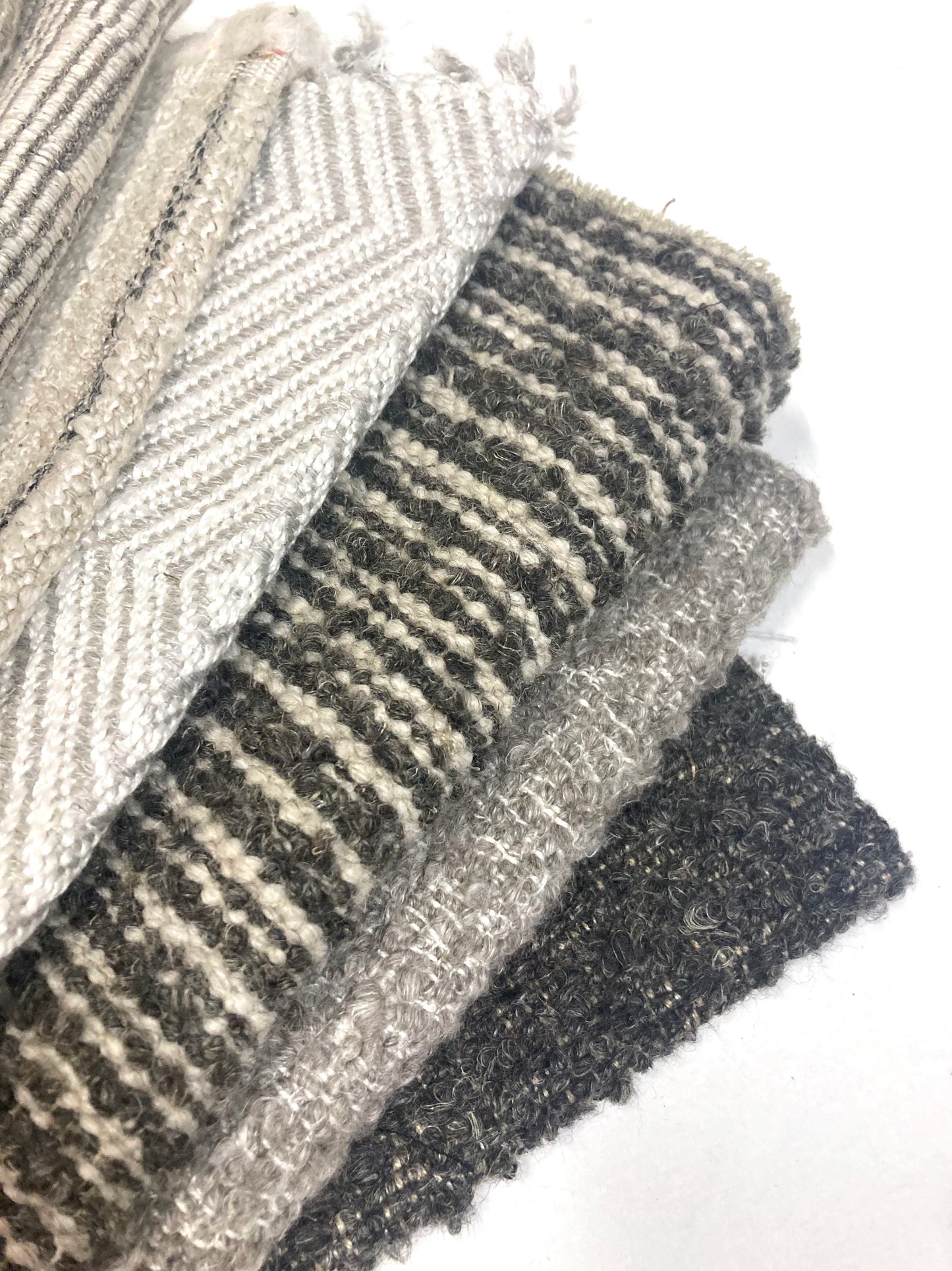 Close-up of several neutral coloured heavyweight fabric, texture visible