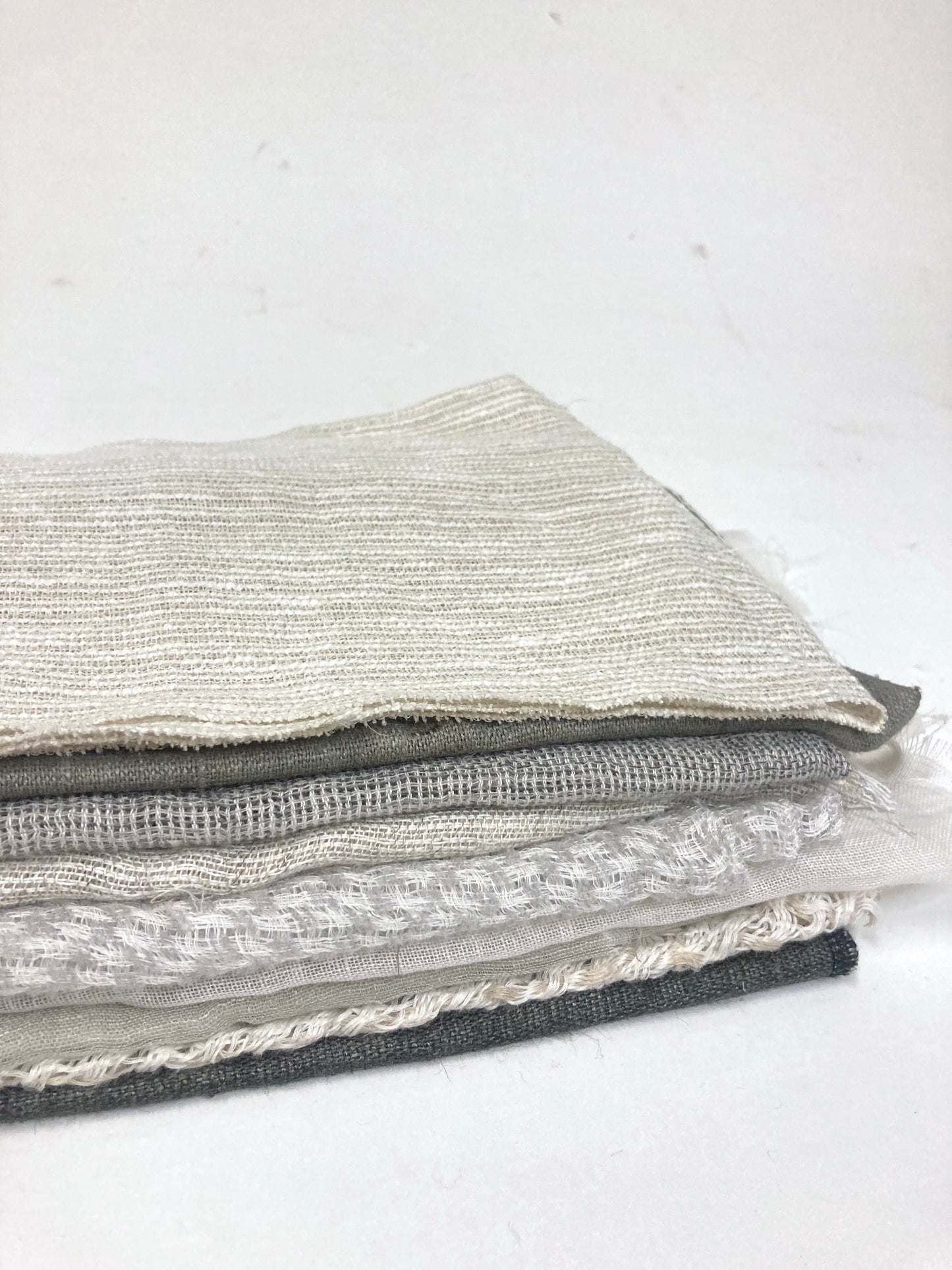 Close-up of a stack of various sized neutral coloured lightweight fabric