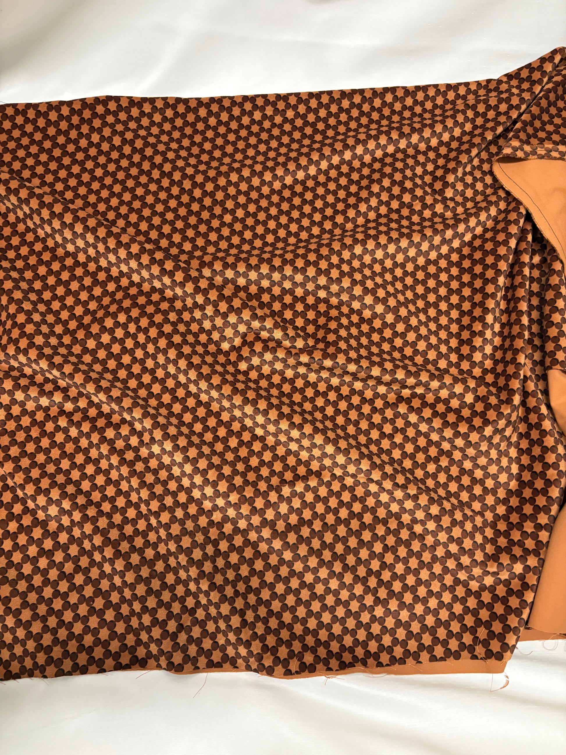 Orange dot patterned velvet fabric, texture visible