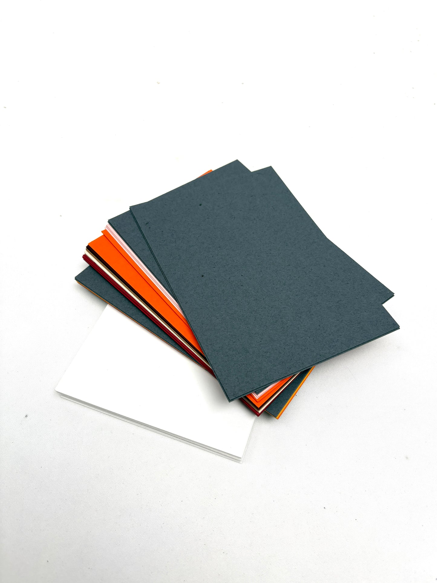 A stack of various coloured papers and a stack white papers 