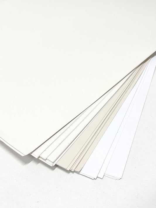 A stack of paper with various types of whites 