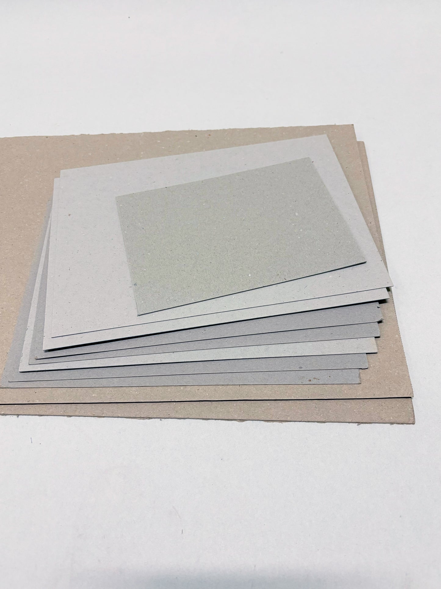A stack of thick sheets of various sizes, thickness, and colours