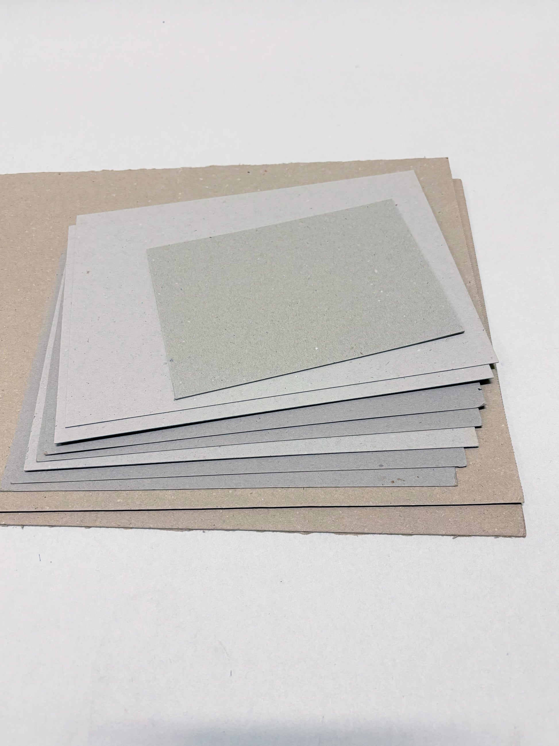 A stack of thick sheets of various sizes, thickness, and colours