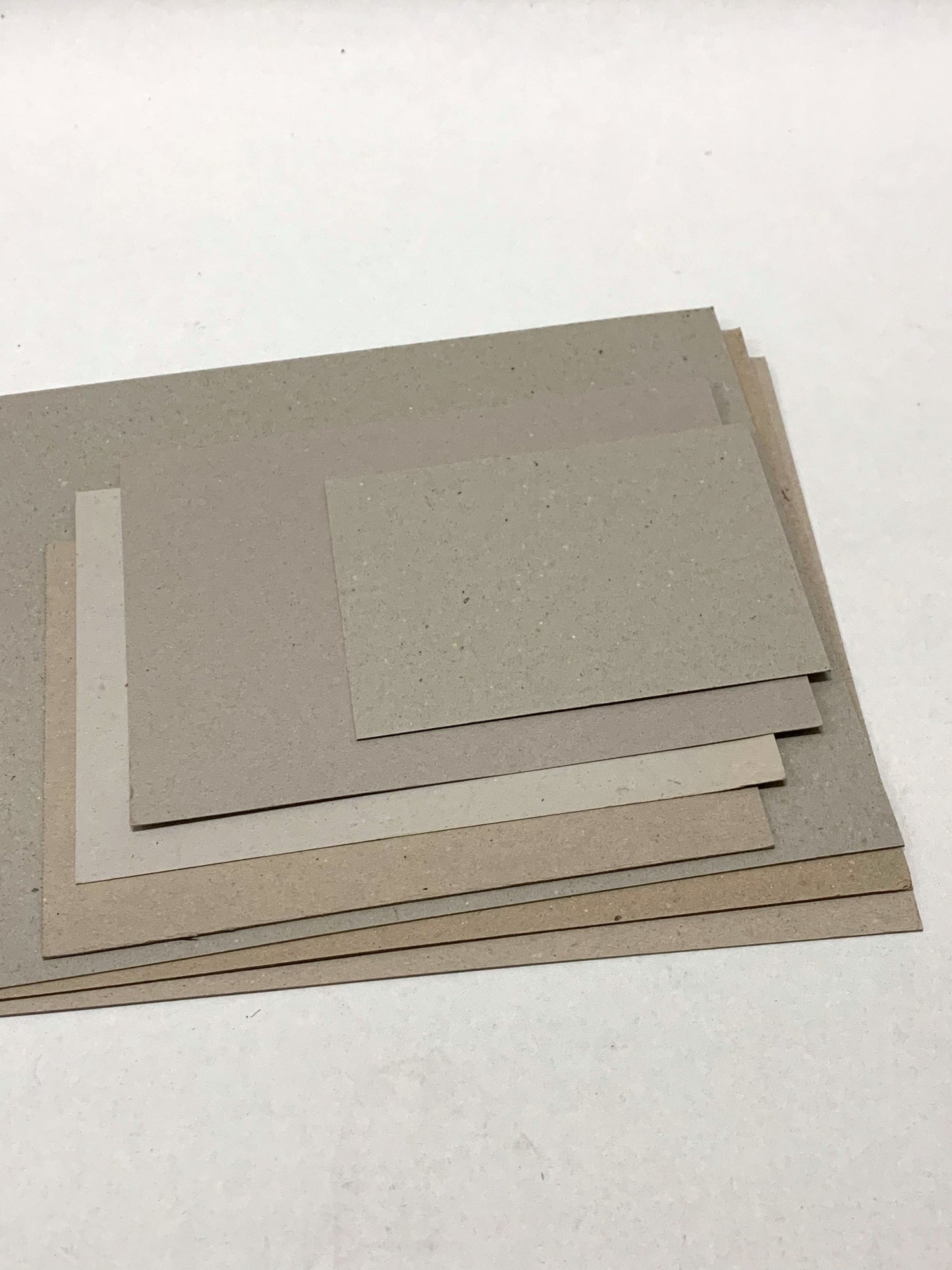 A stack of thick sheets of various sizes, thickness, and colours