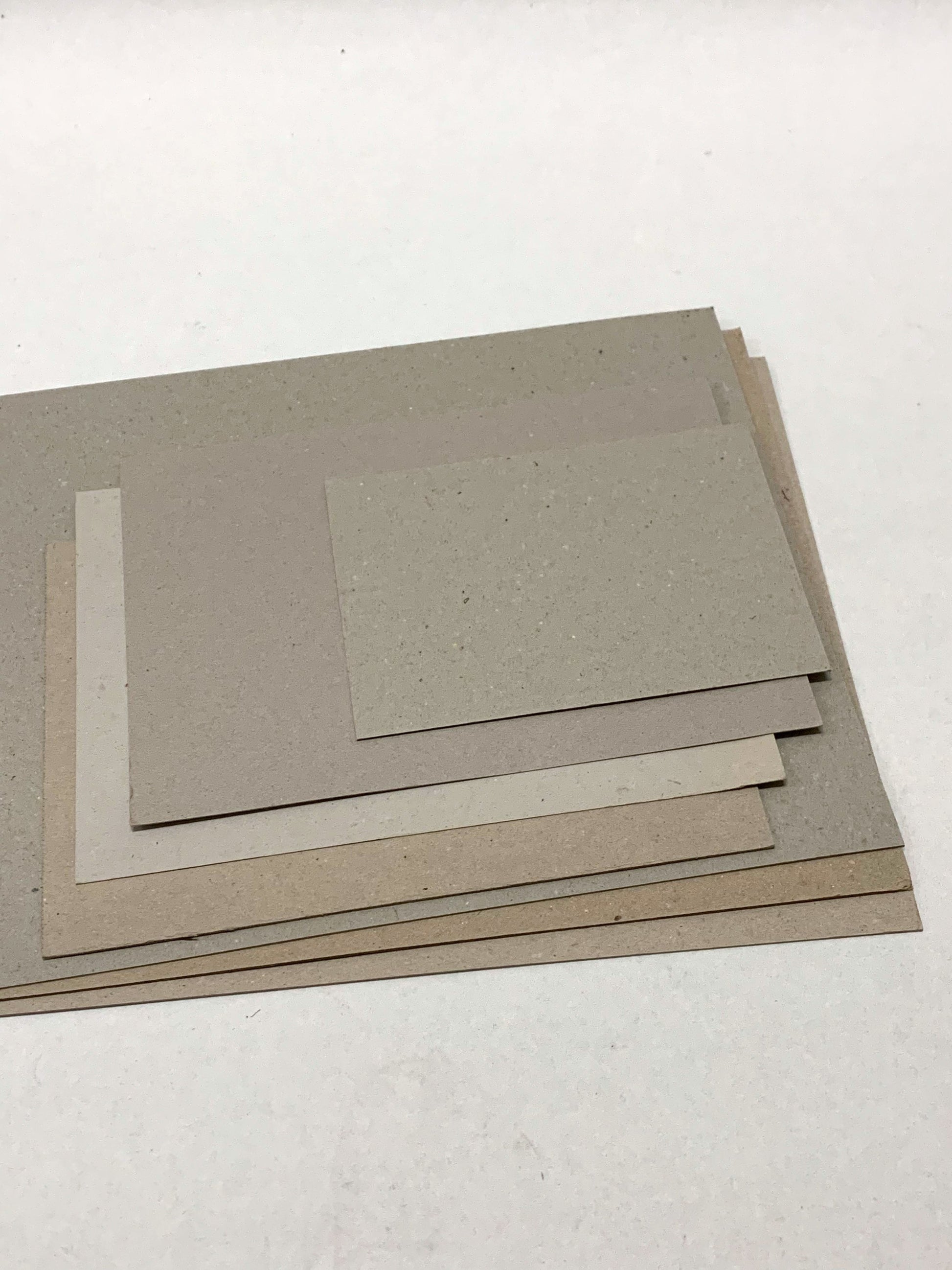 A stack of thick sheets of various sizes, thickness, and colours