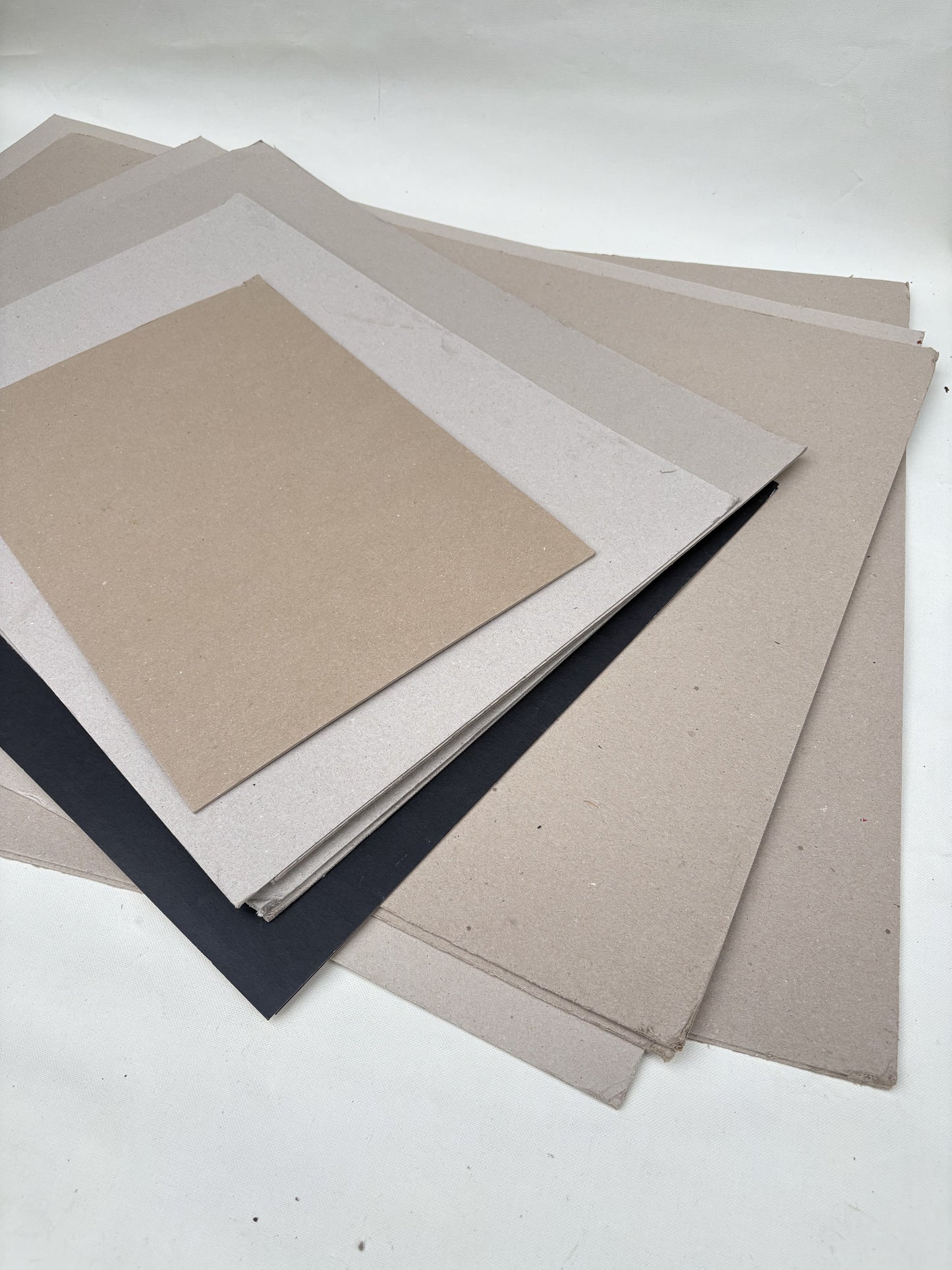 A stack of thick sheets of various sizes, thickness, and colours