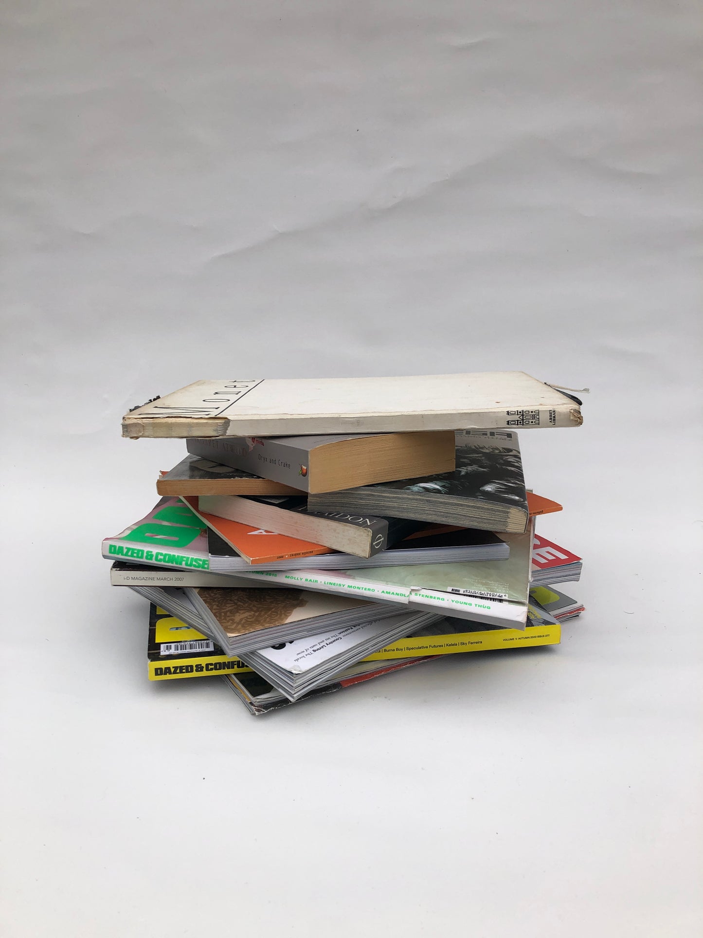 Piles of paper magazines and books, some torn and stained 
