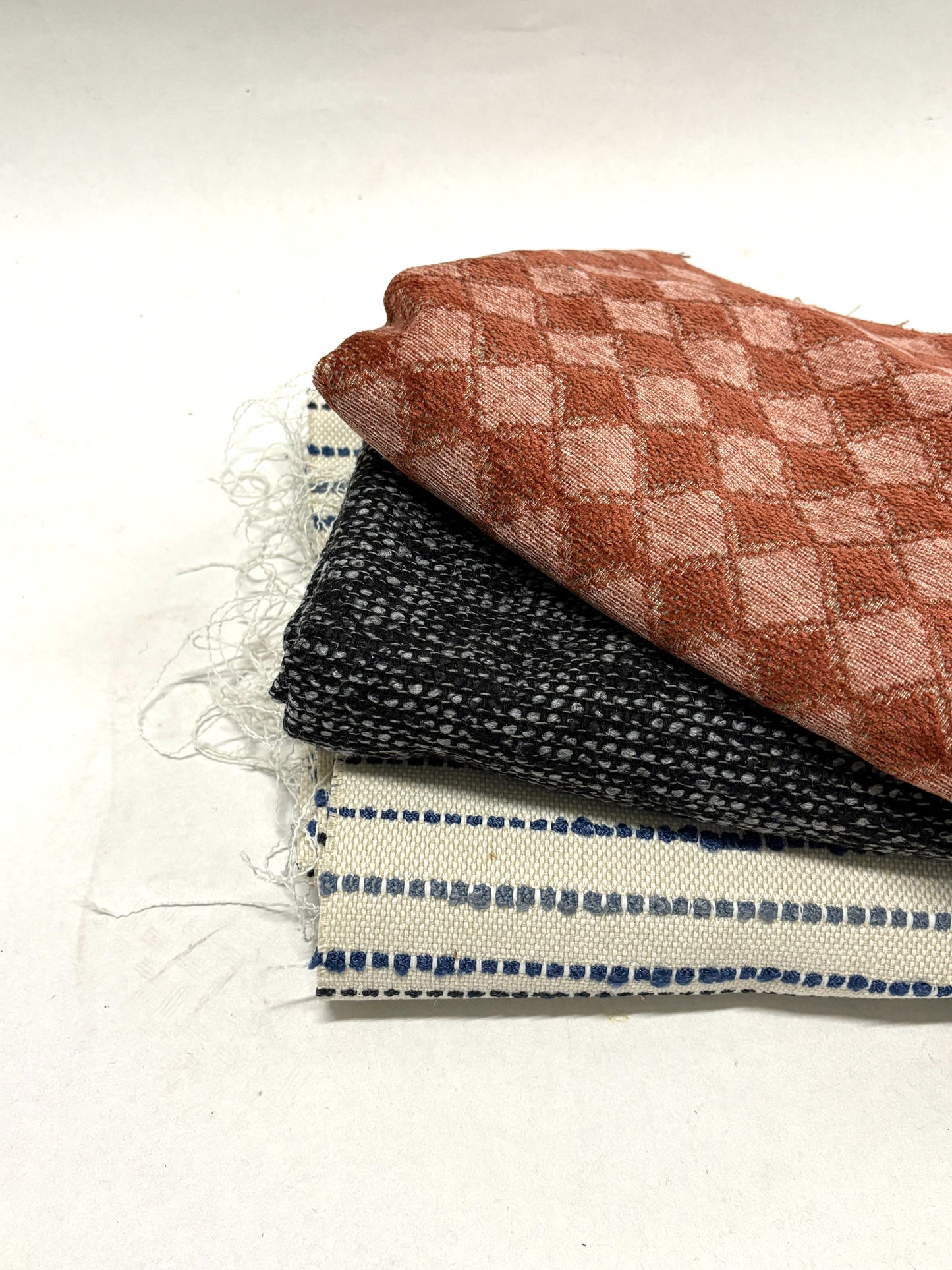 Stack of three checkered and patterned fabric with red, black, and white