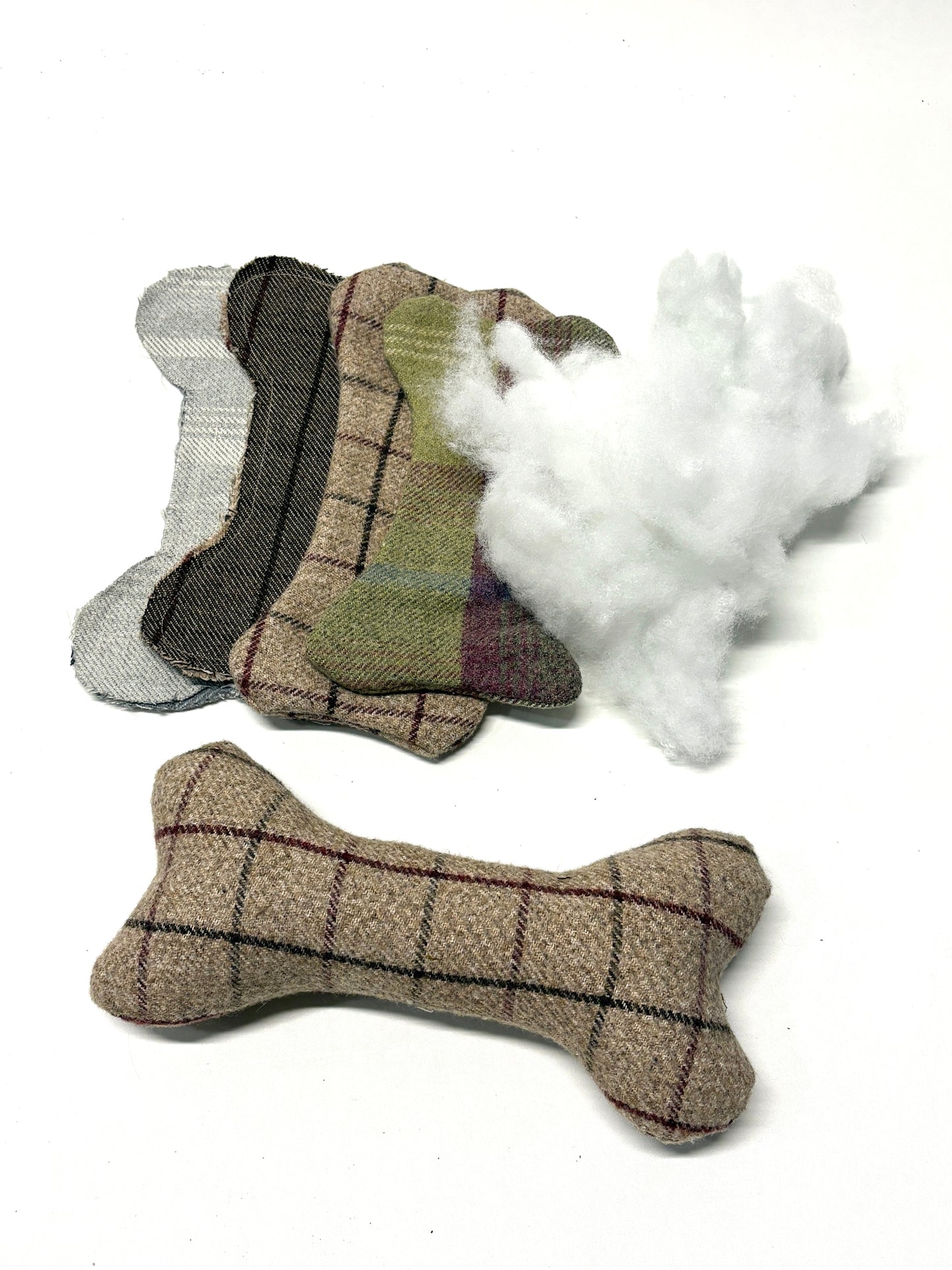 Bone-shaped fabric dog toy and empty bone-shaped toy (stuffing for the inside is next to it)