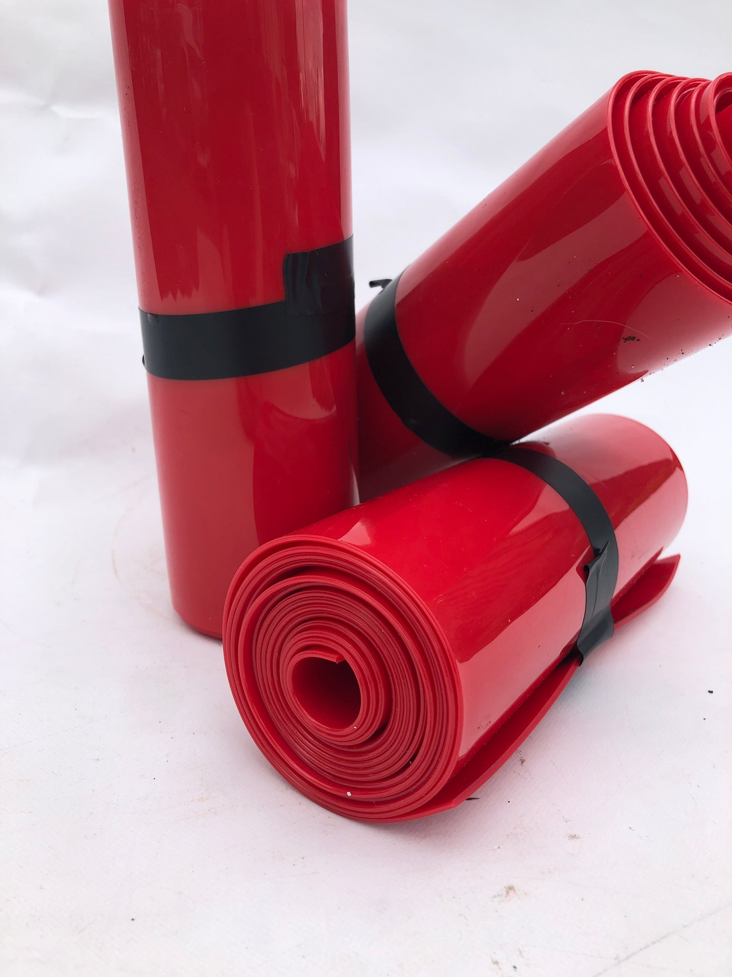 Close-up of 3 rolled up red plastic strips curtain