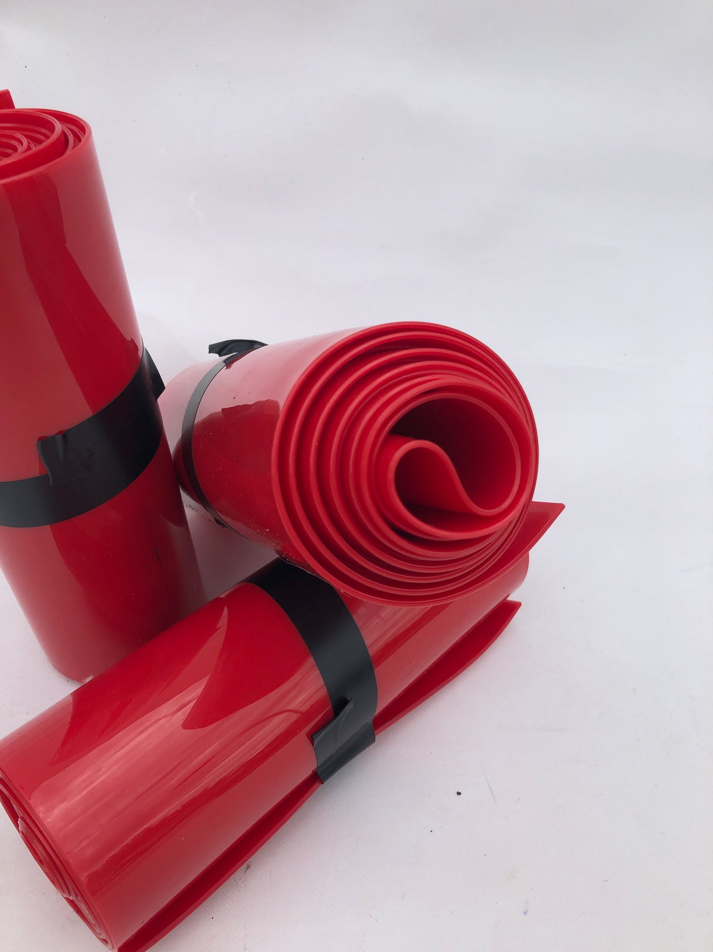 Close-up of 3 rolled up red plastic strips curtain