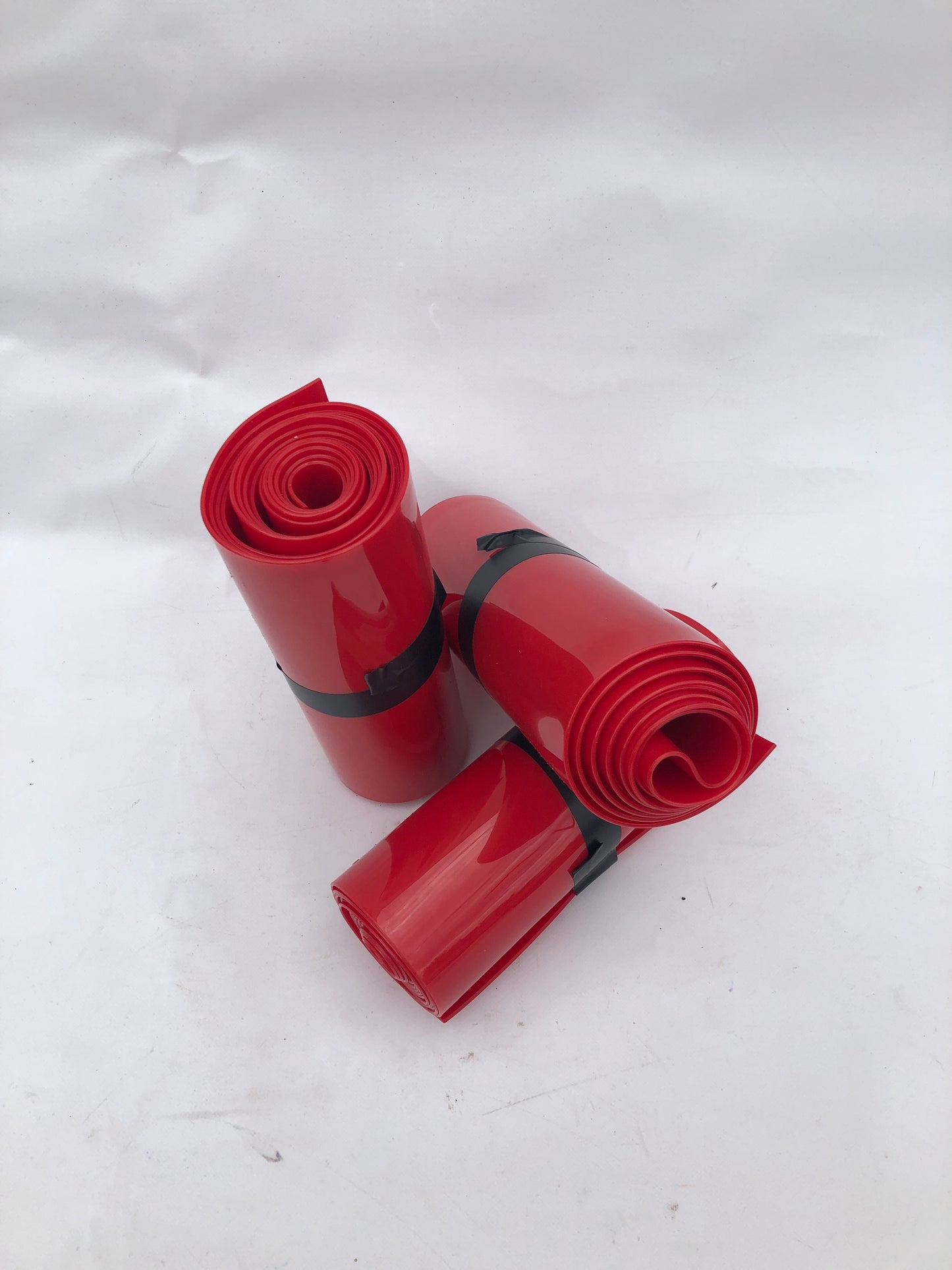 3 rolled up red plastic strips curtain