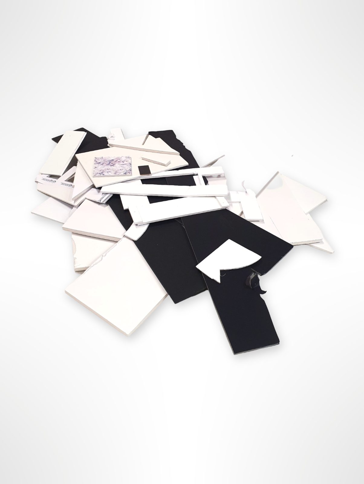 A collection of black and white foam board offcuts of various sizes