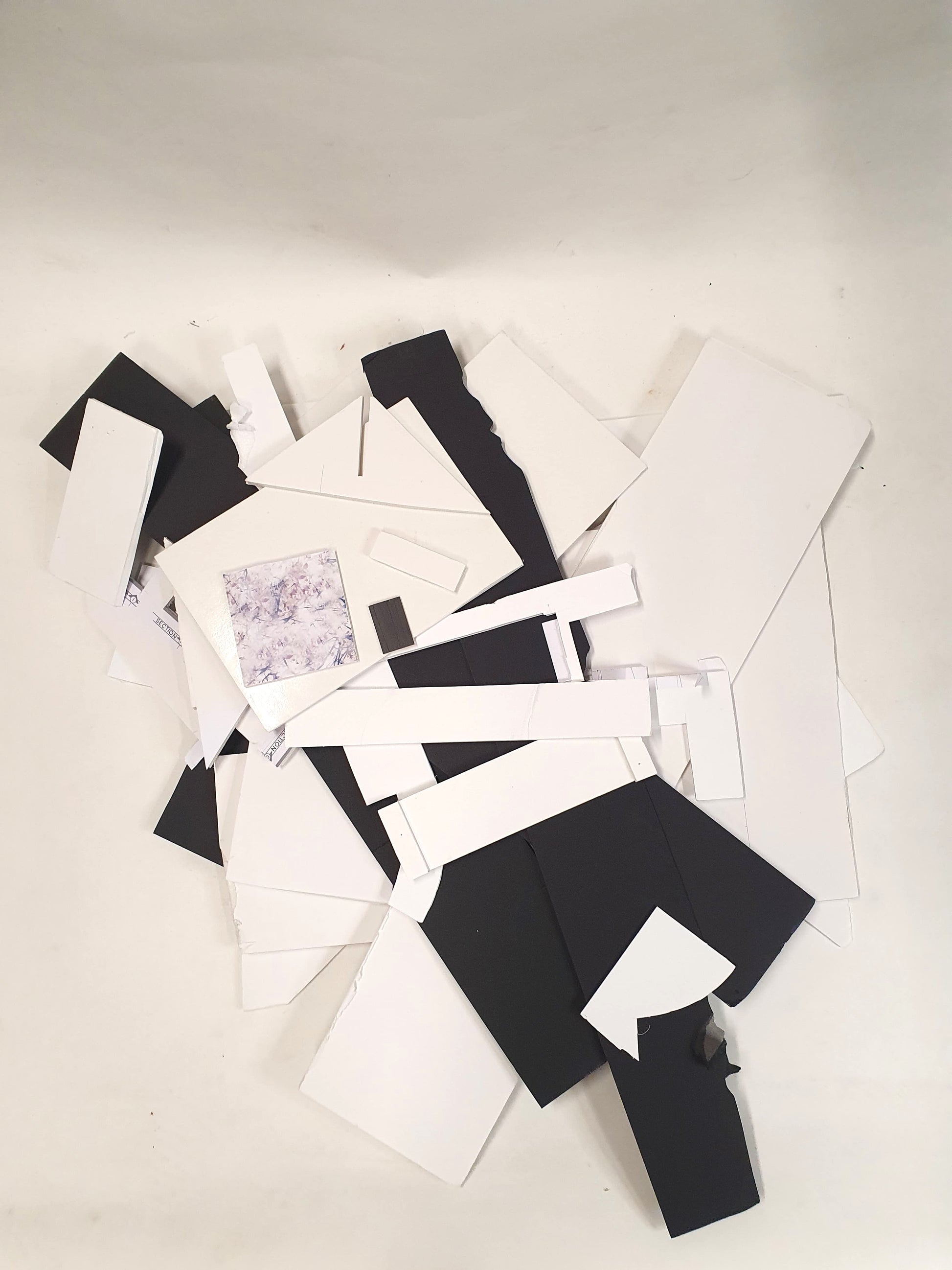 A collection of black and white foam board offcuts of various sizes