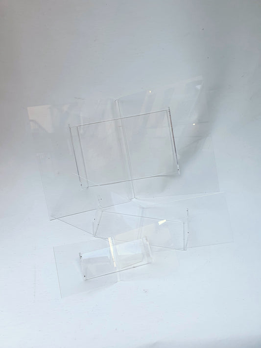 Several clear plastic perspex book cradles of various sizes
