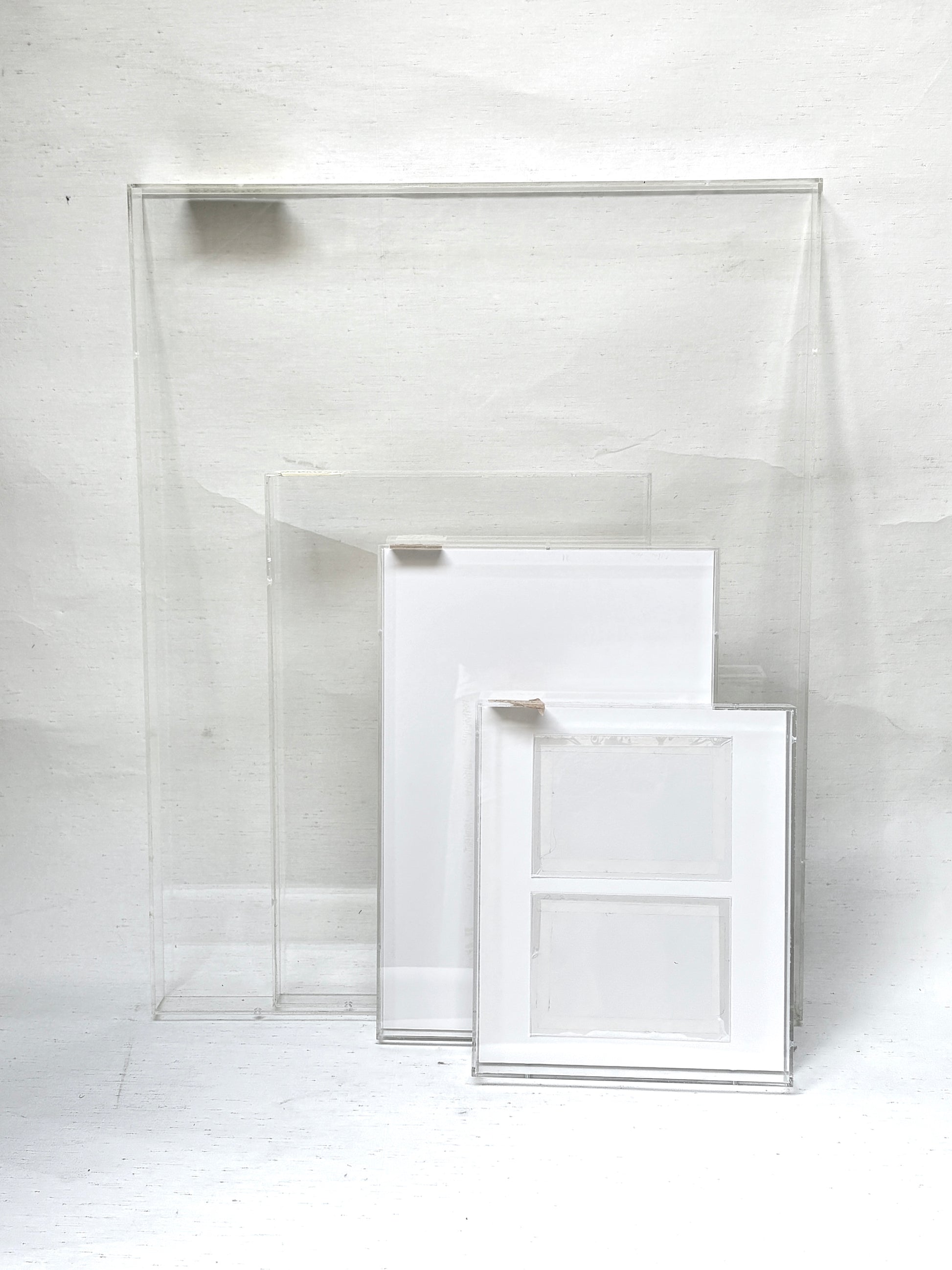 A collection of 4 varying sizes of the clear rectangular perspex frames 