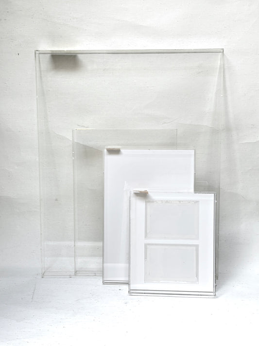 A collection of 4 varying sizes of the clear rectangular perspex frames 