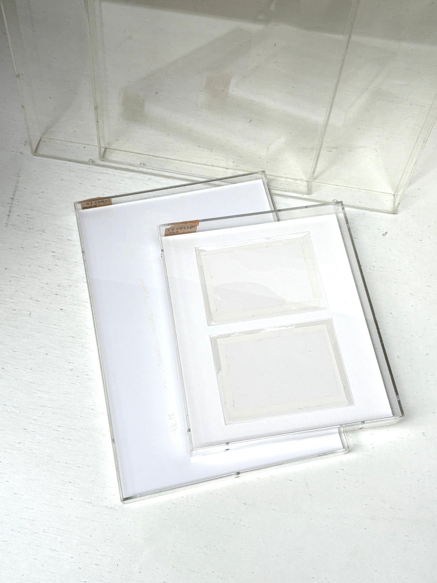A collection of 4 varying sizes of the clear rectangular perspex frames with white paper inside