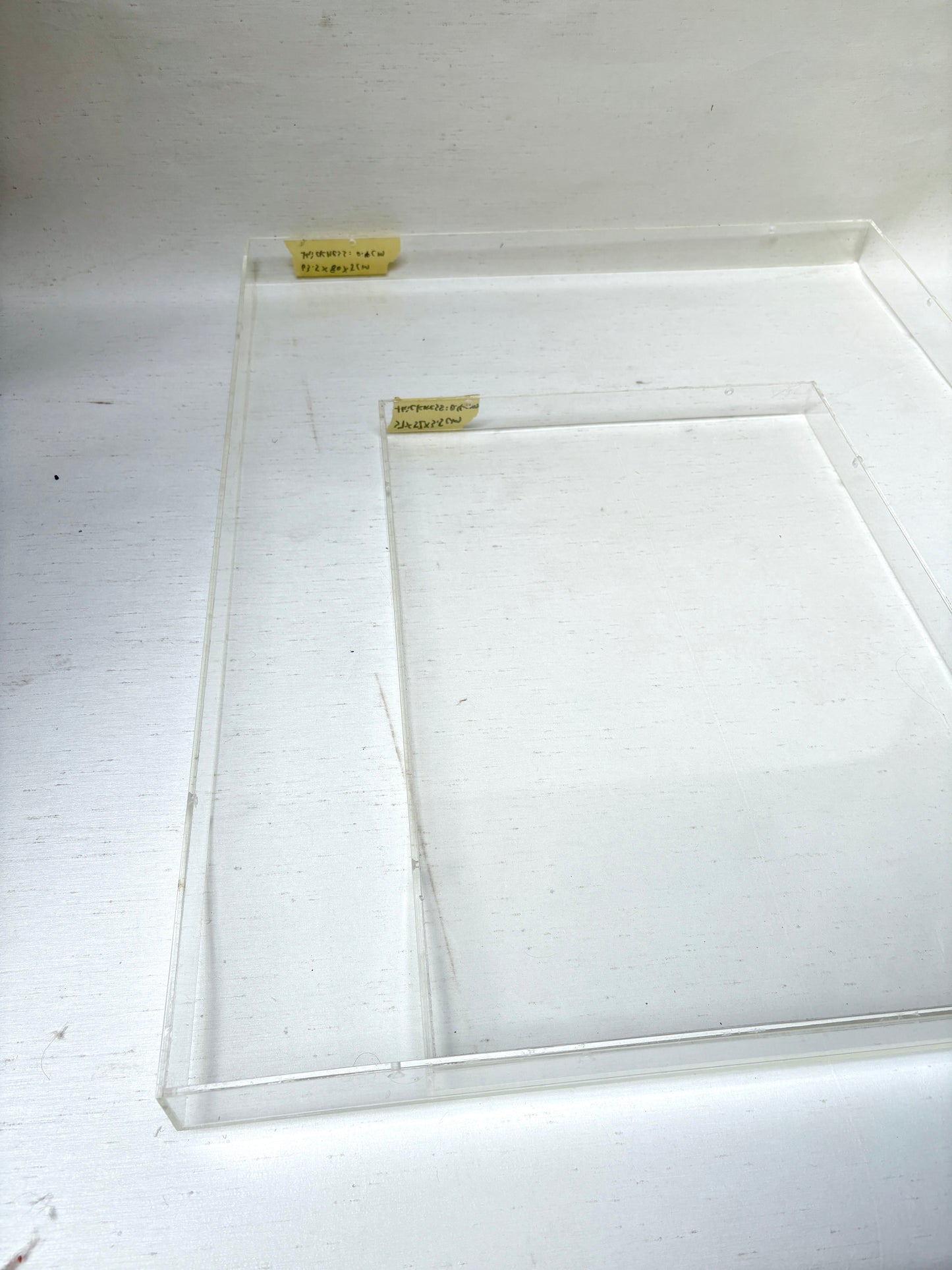 Close-up of 2 different sizes of the clear rectangular perspex frames 